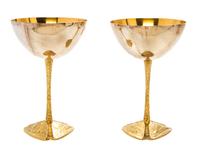 A Pair of Silver and Silver-Gilt Commemorative Goblets, Stuart Devlin, 1973, each raised on a tripartite foot embossed with scenes of t