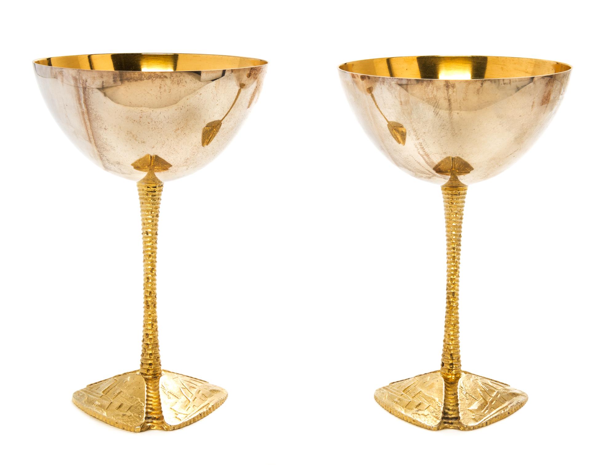 A Pair of Silver and Silver-Gilt Commemorative Goblets, Stuart Devlin, 1973, each raised on a tripartite foot embossed with scenes of t