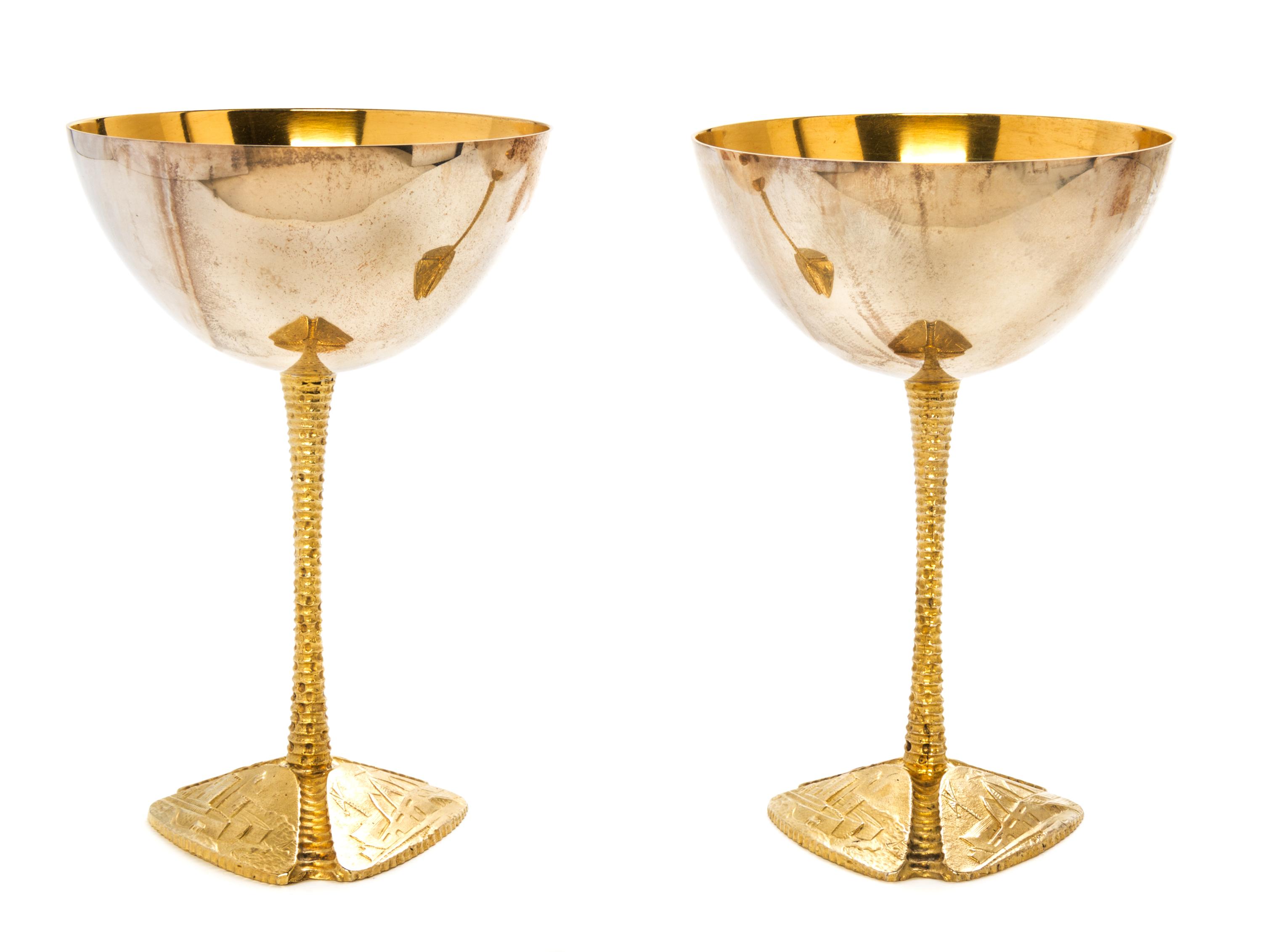A Pair of Silver and Silver-Gilt Commemorative Goblets, Stuart Devlin, 1973, each raised on a tripartite foot embossed with scenes of t