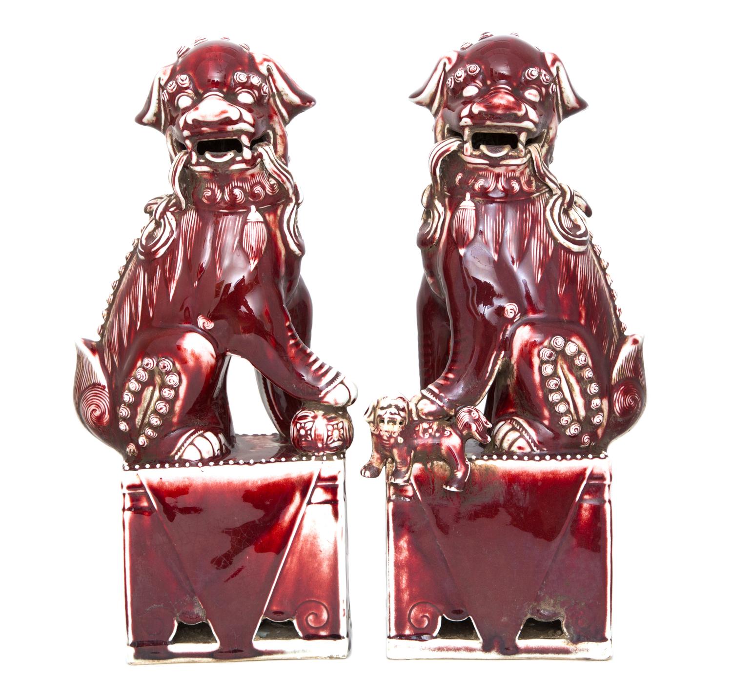A Pair of Chinese Sang de Boeuf Glazed Pottery Fu Lions Height 16 inches. — 20TH CENTURY