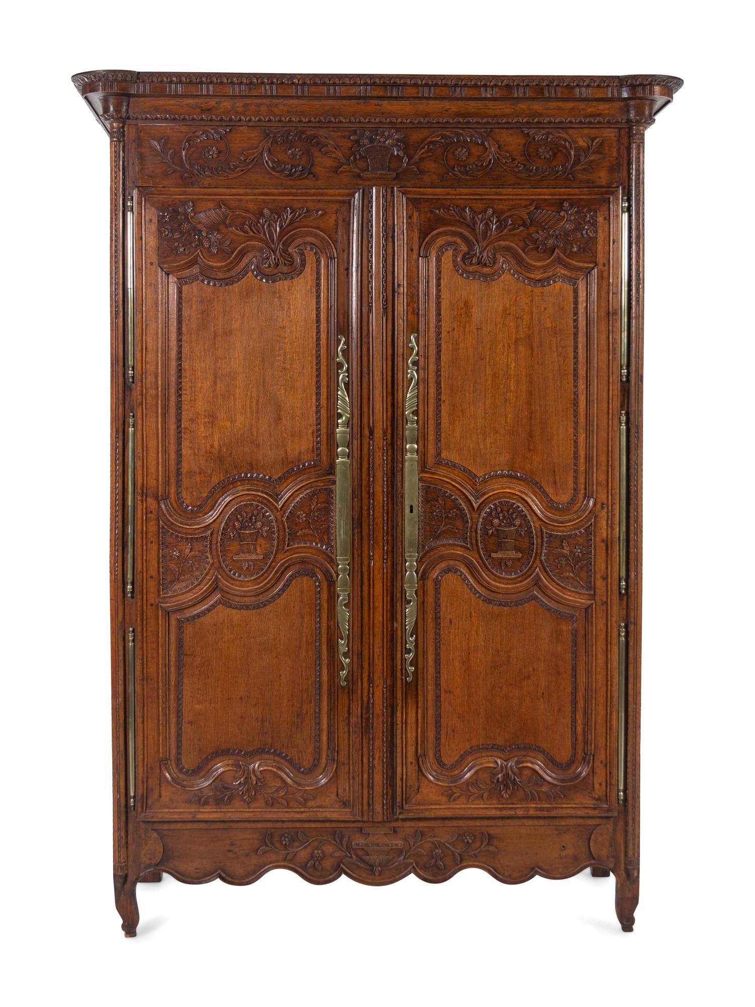 A Louis XV Provincial Brass Mounted Carved Oak Armoire