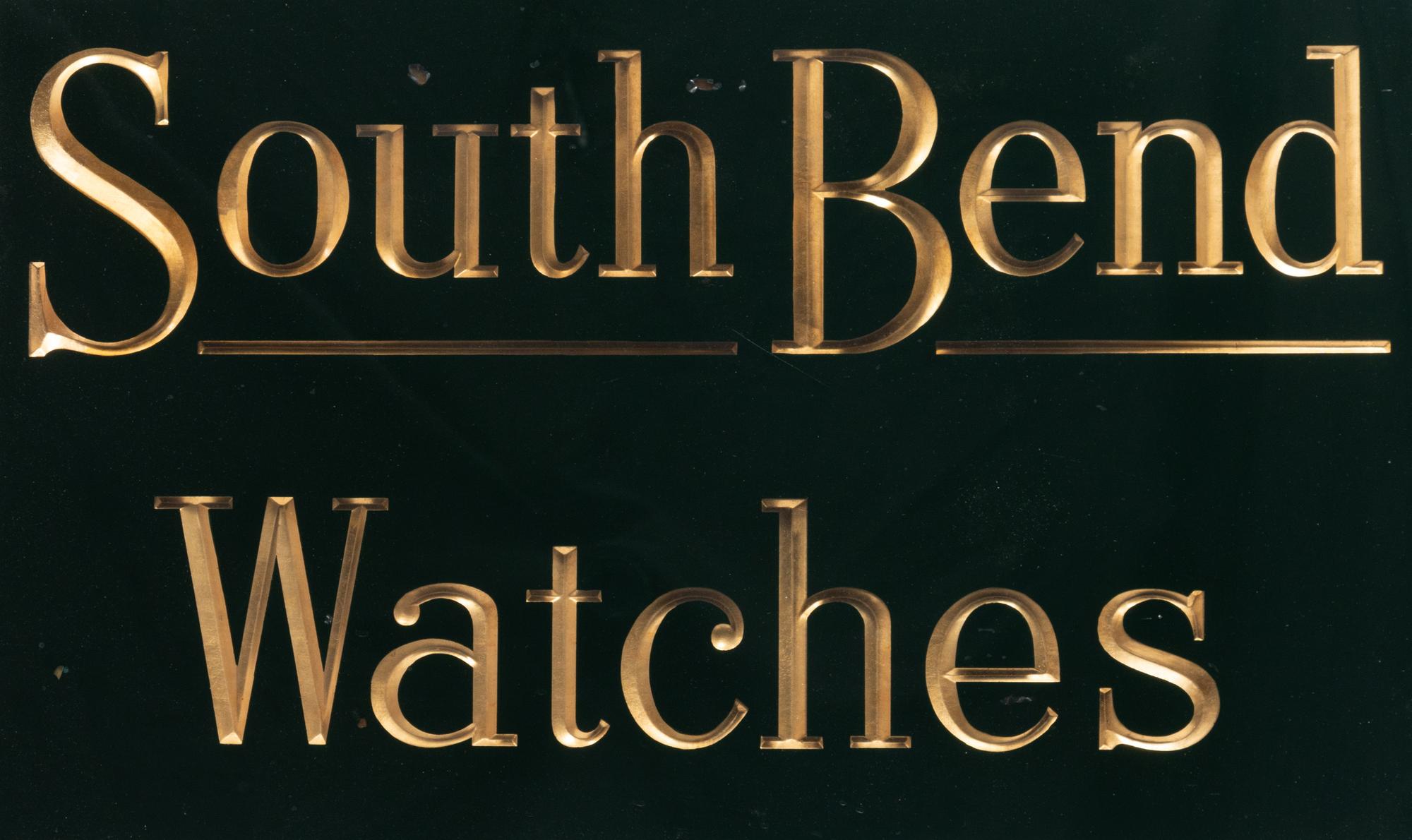 A Reverse Paint and Parcel Gilt South Bend Watches Advertising Sign