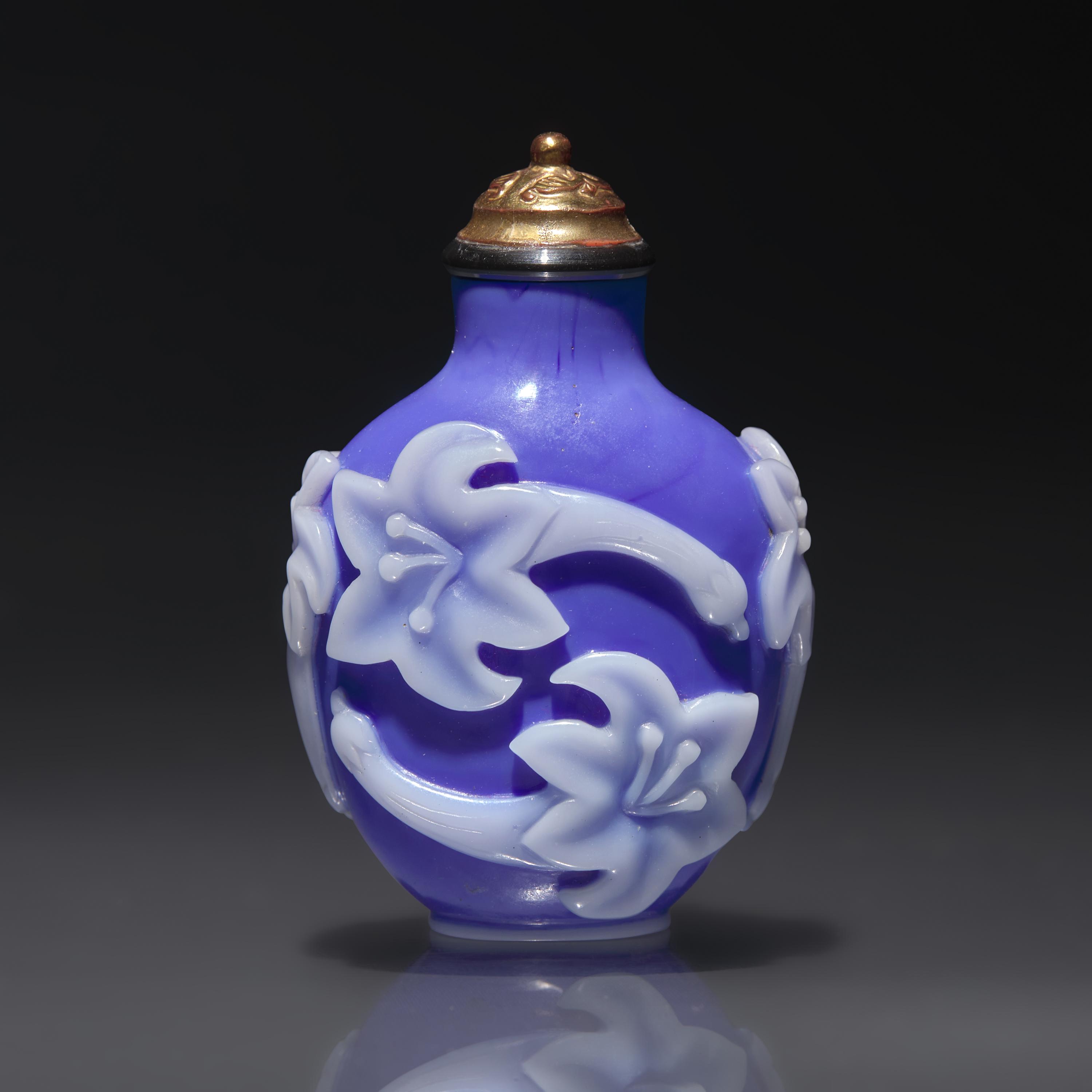 A Chinese White Overlaid Blue Glass Snuff Bottle, Qing Dynasty, 18th Century — 清中期 寶石藍地套白料萱花紋鼻煙壺