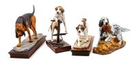 A Group of Four Dog Figures of Various Breed Width of widest 14 1/2 inches.