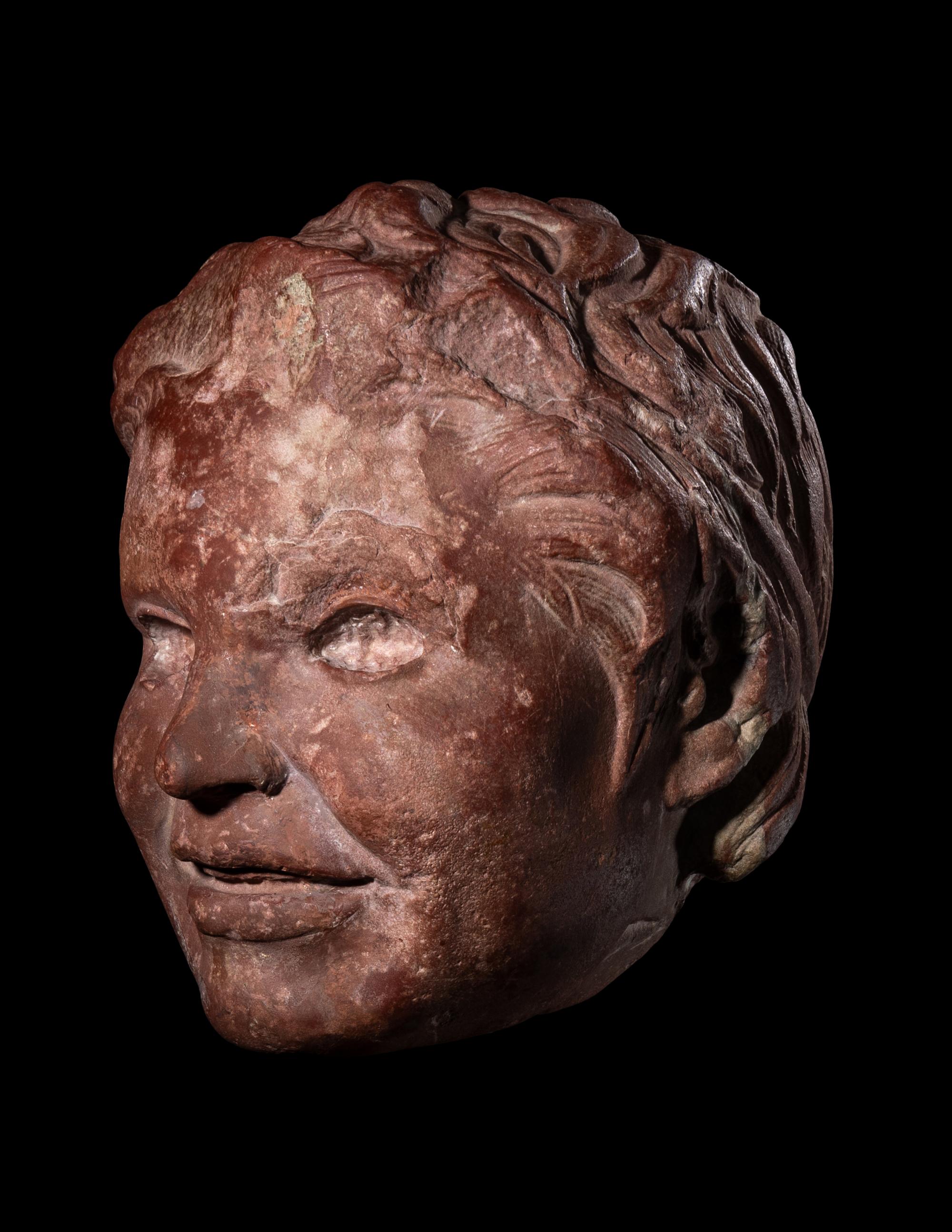 A Roman Rosso Antico Head of a Young Satyr