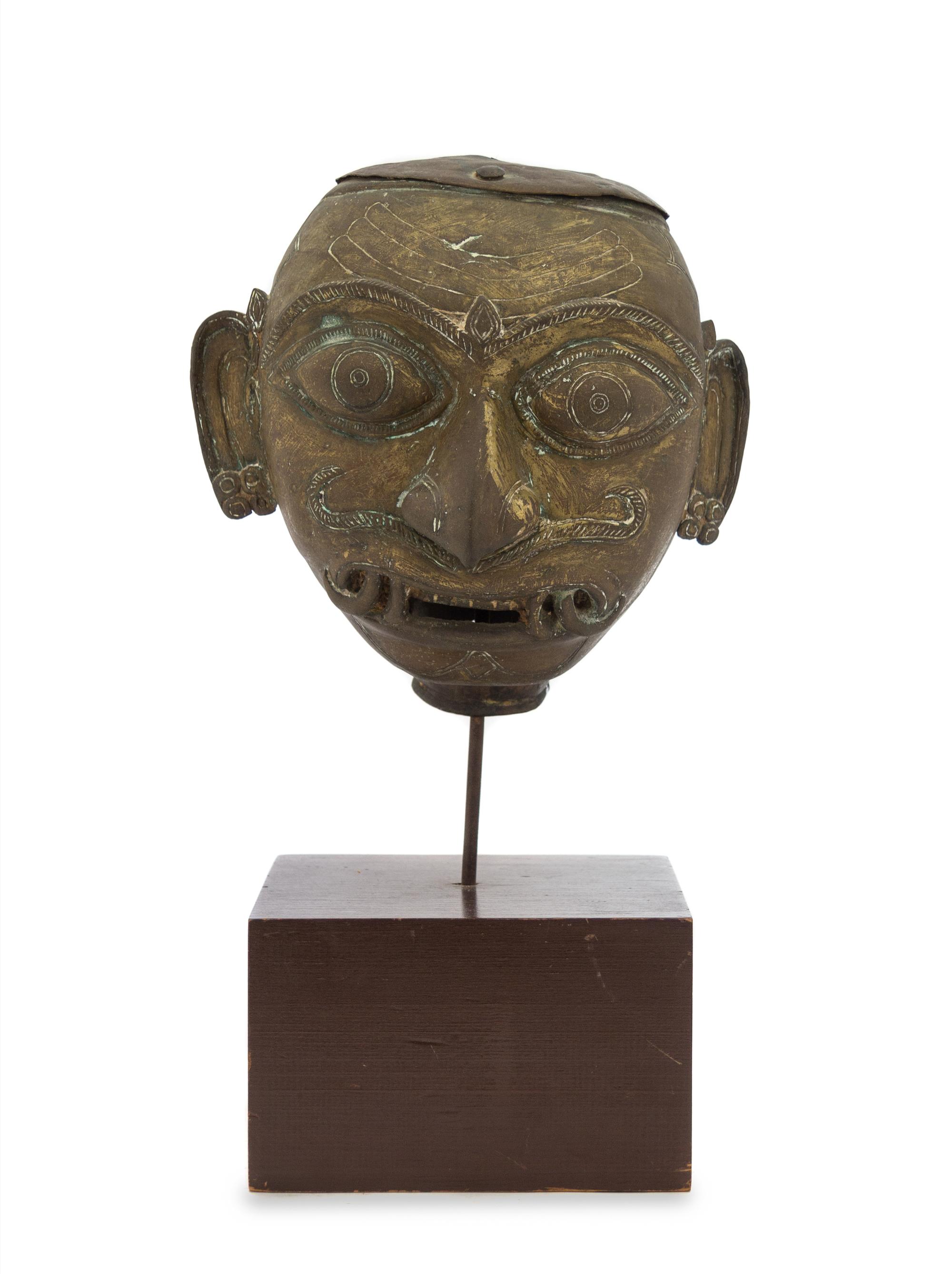 An Indian Bronze Head of a Deity 18TH/19TH CENTURY Height overall 14 inches. — 18TH/19TH CENTURY