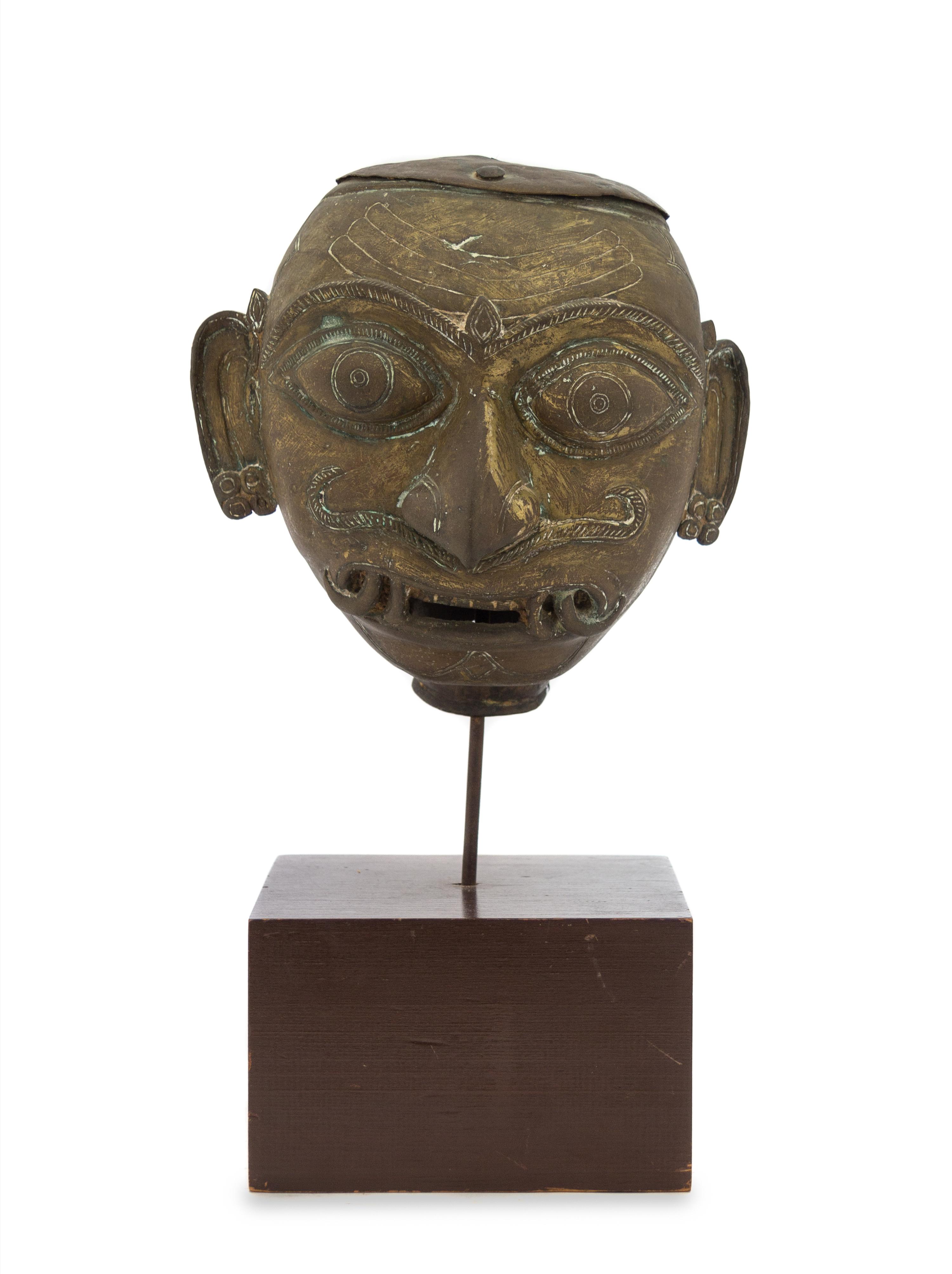 An Indian Bronze Head of a Deity 18TH/19TH CENTURY Height overall 14 inches. — 18TH/19TH CENTURY