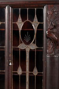 An Aesthetic Movement Crane and Mask Carved Mahogany and Glass Paneled Bookcase