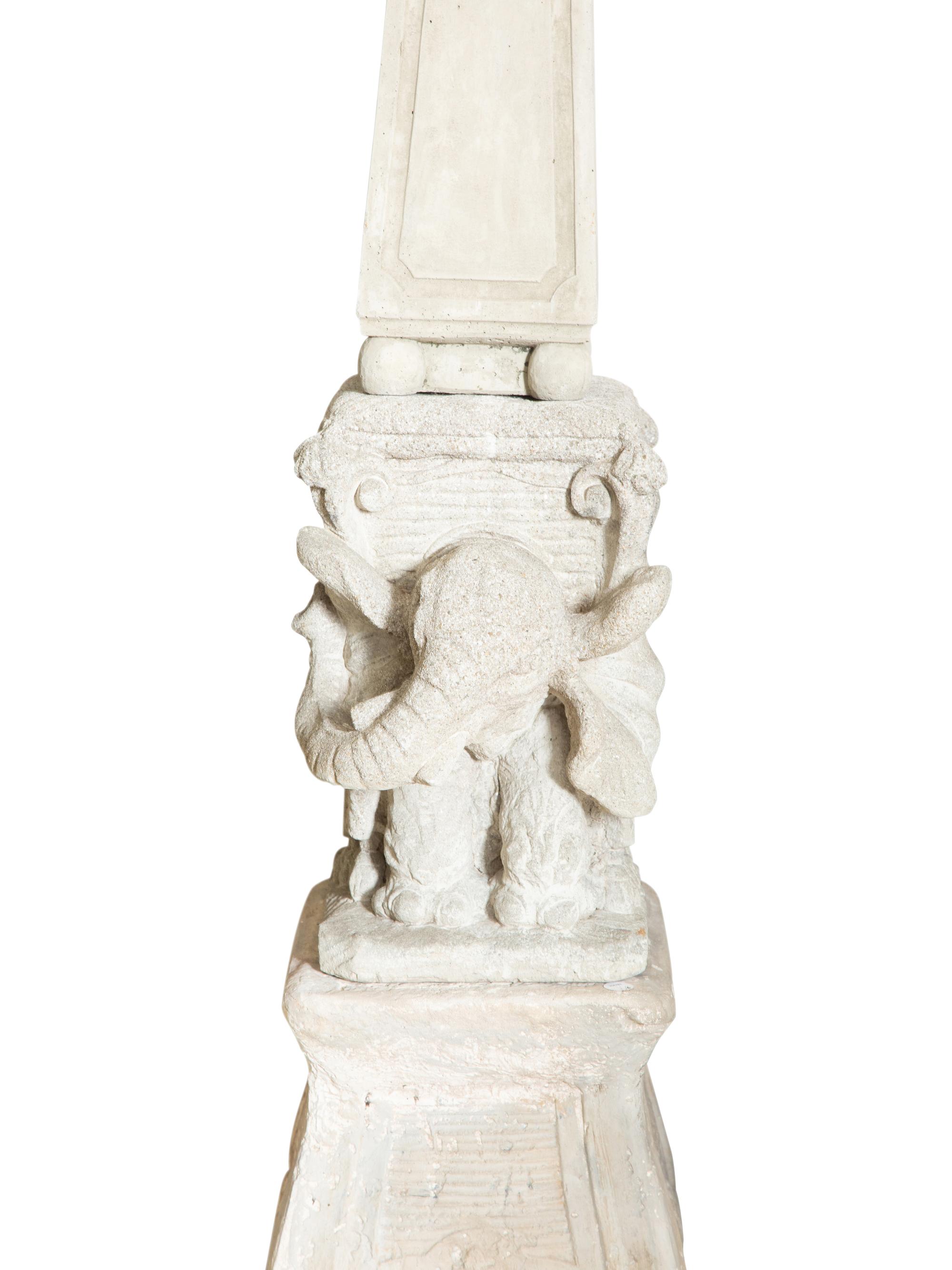 A Pair of Cast Stone Obebelisks on Elephant-Form Pedestals