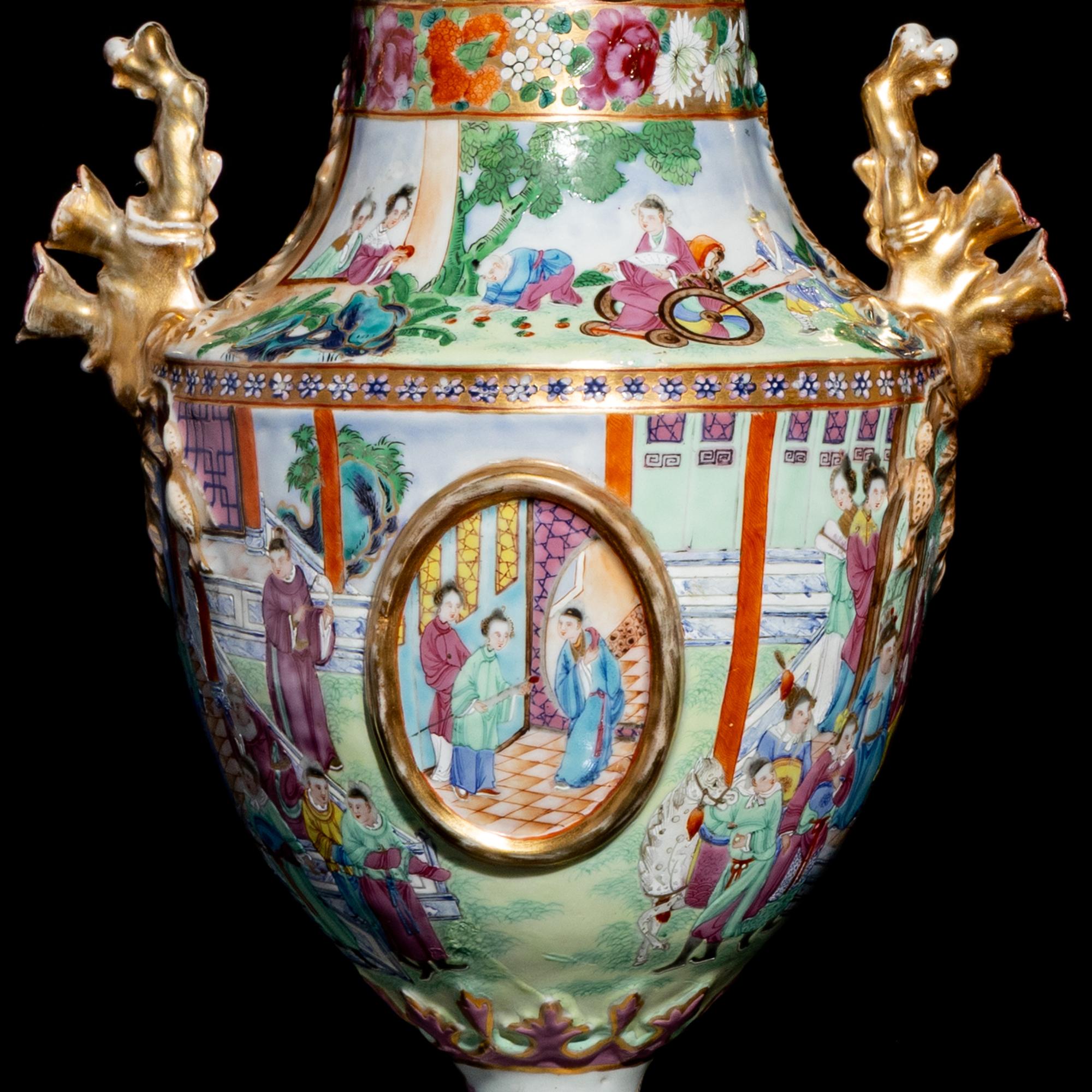 A Pair of Chinese Export Canton Famille Rose Porcelain Covered Urns, Early 19th Century — 清晚期 外銷廣彩人物故事圖獎杯形賞瓶一對