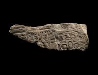 An Egyptian Limestone Relief Fragment Depicting an Attendant Wearing a Head-Cone