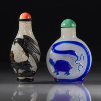 Two Chinese Carved Overlay Glass Snuff Bottles, Qing Dynasty, Circa 1780-1850 — 1780-1850年 雪霏地套黑料及藍料鼻煙壺兩支