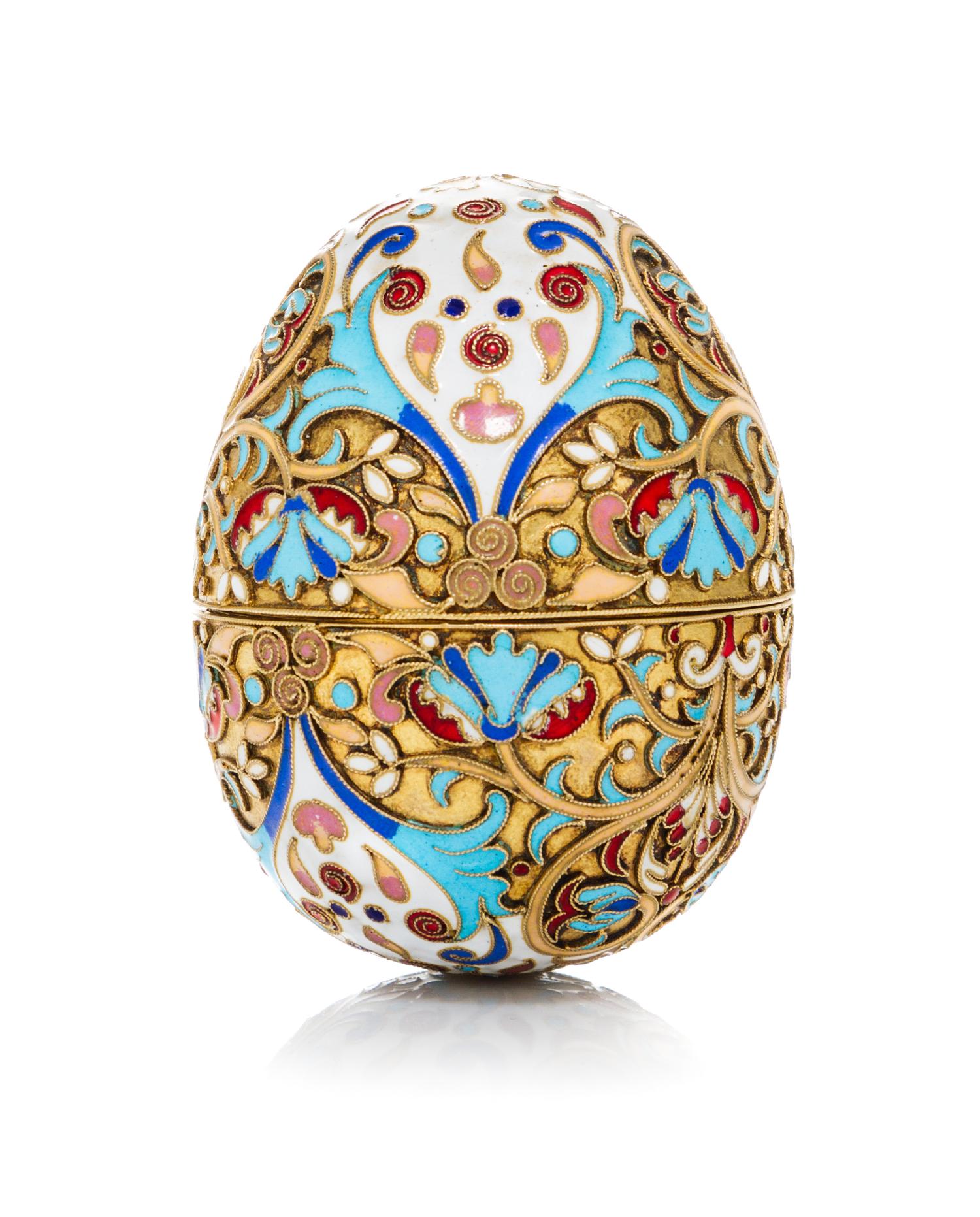 A Russian Enameled Silver Egg, 19th Century, in two parts with floral and foliate decoration.
