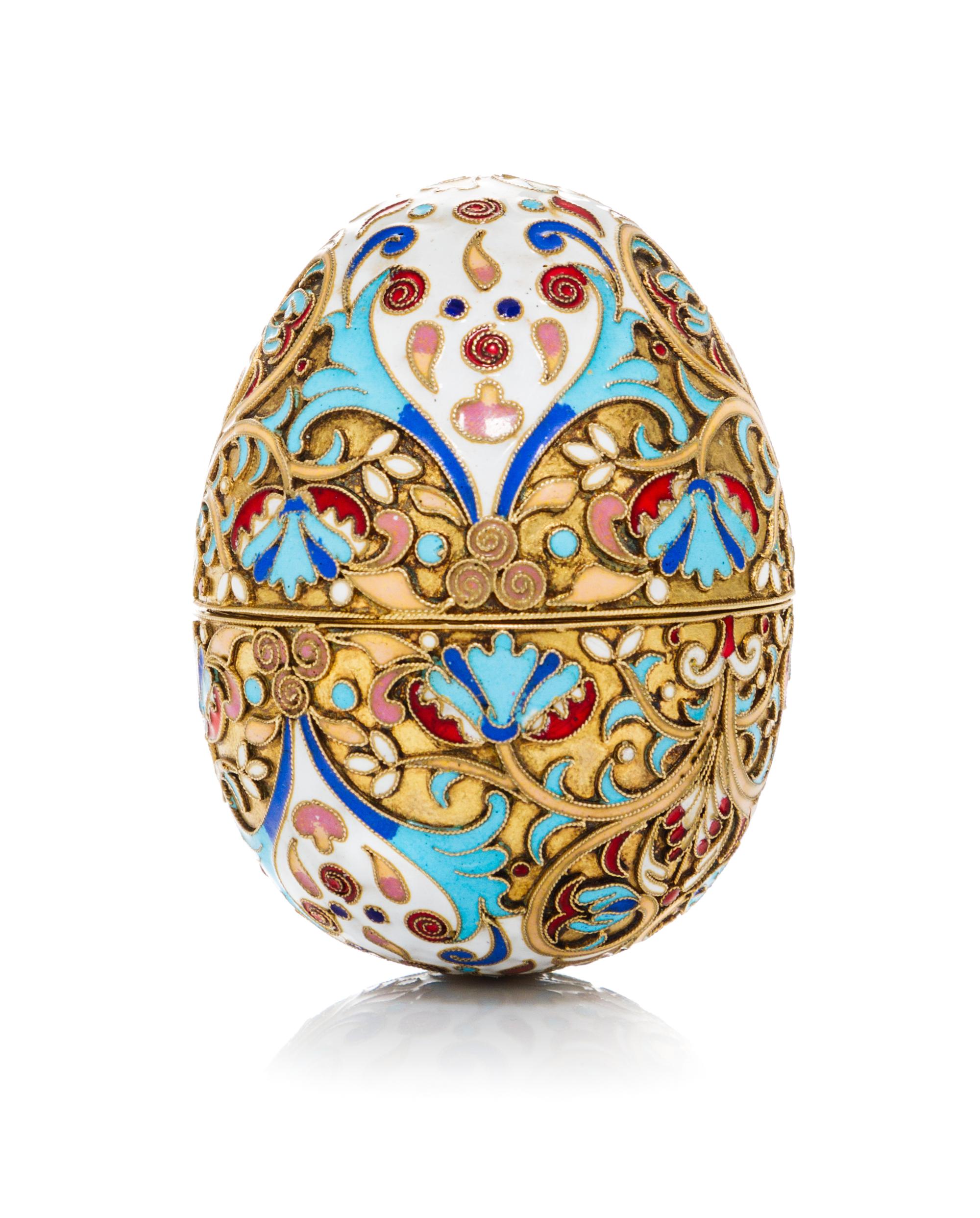 A Russian Enameled Silver Egg, 19th Century, in two parts with floral and foliate decoration.