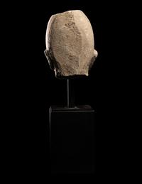 A Cypriot Limestone Head of a Man Wearing a Helmet