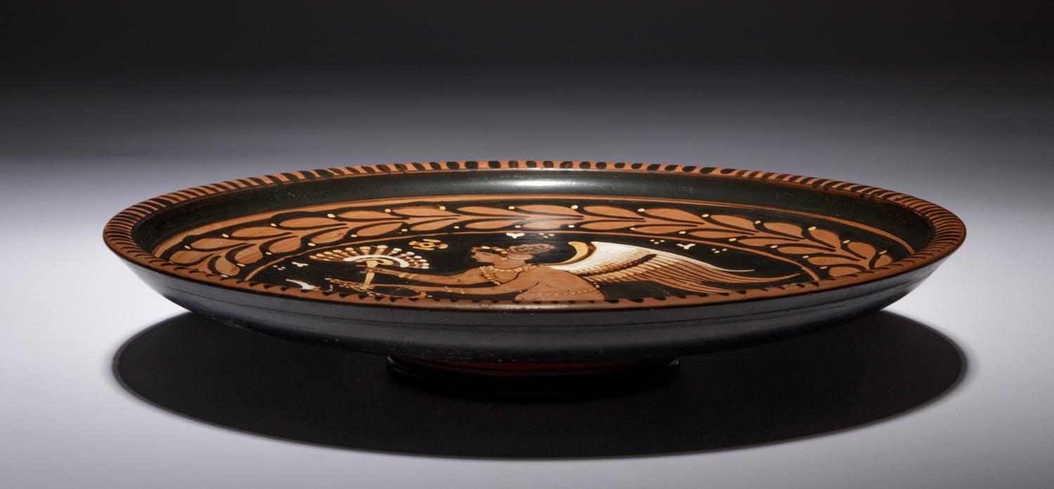 An Apulian Red-Figured Plate with Striding Eros