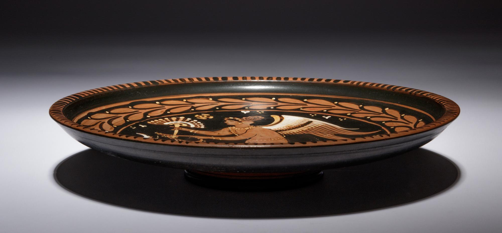 An Apulian Red-Figured Plate with Striding Eros
