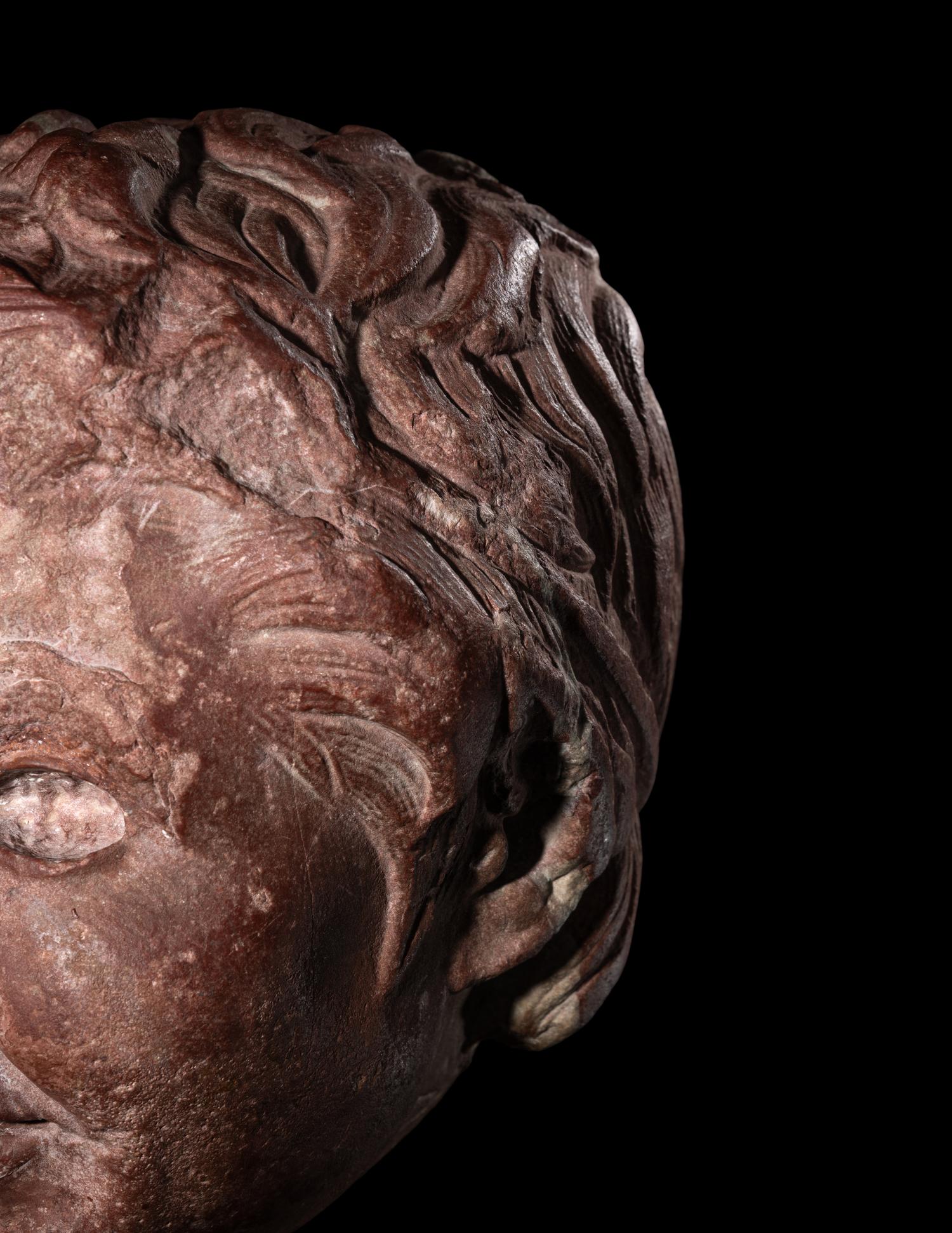 A Roman Rosso Antico Head of a Young Satyr