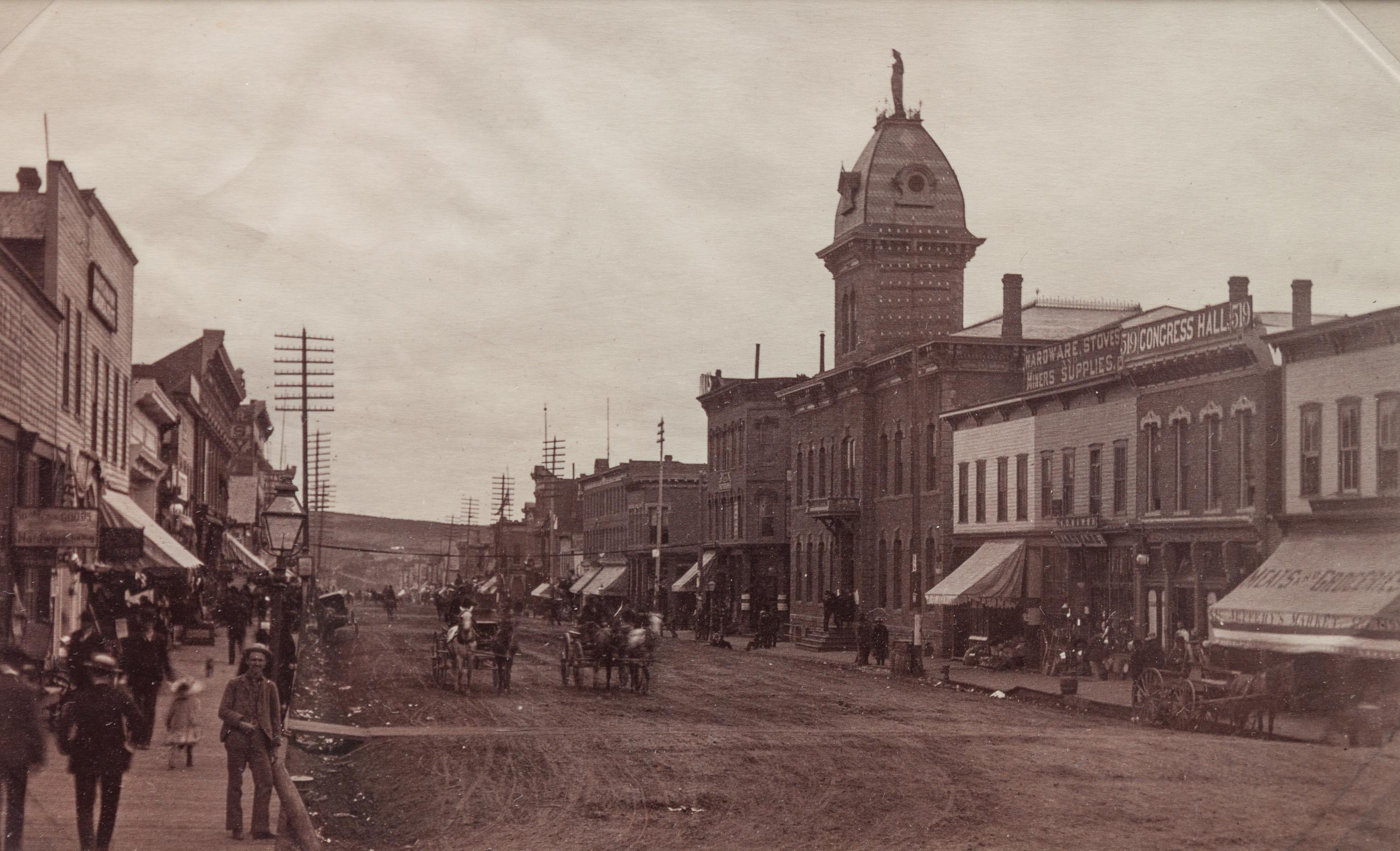 A group of three photographs (3647. Miners at Home; Untitled (main street); 2209. Dug Out - Bluer River Valley)