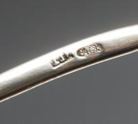 A Russian Enameled Silver Spoon, Maker's mark obscured, Moscow, the back of the circular bowl worked with flower heads against a textur
