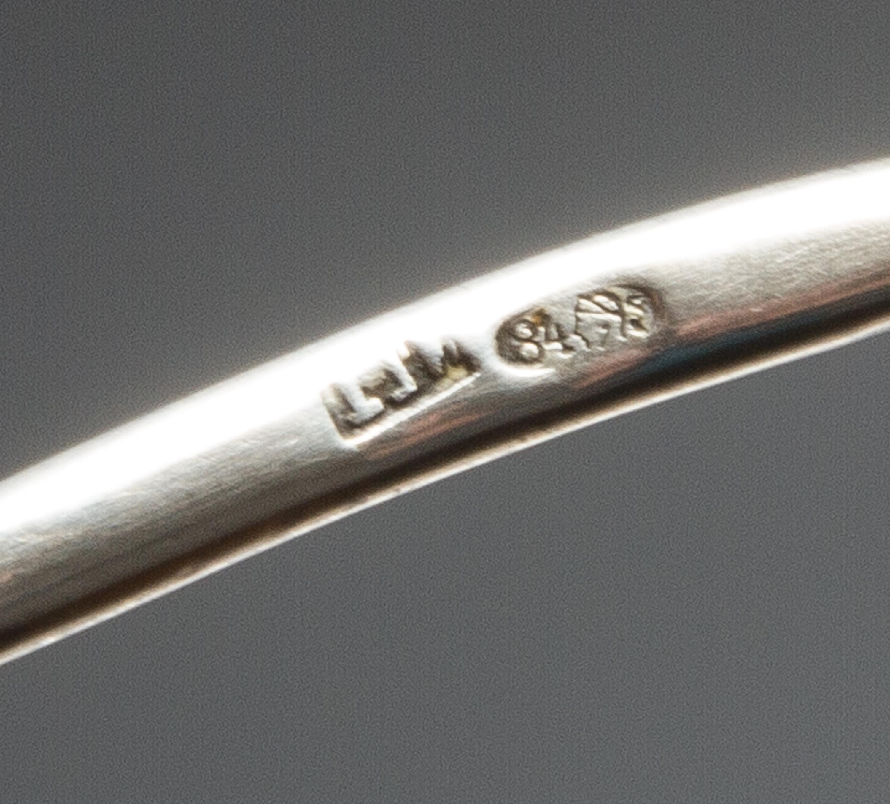 A Russian Enameled Silver Spoon, Maker's mark obscured, Moscow, the back of the circular bowl worked with flower heads against a textur