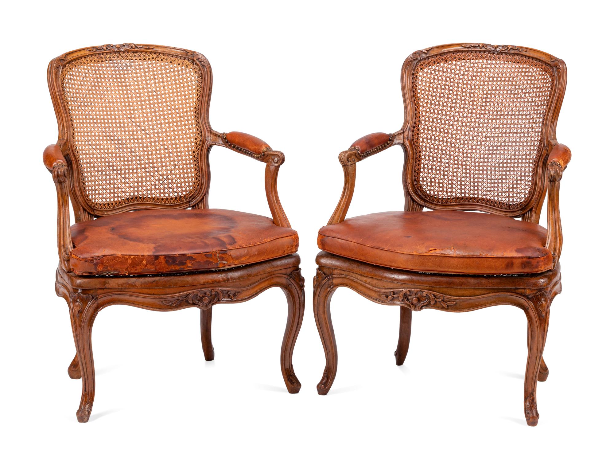 A Pair of Louis XV Beechwood Fauteuils with Cane and Leather Seat Cushions