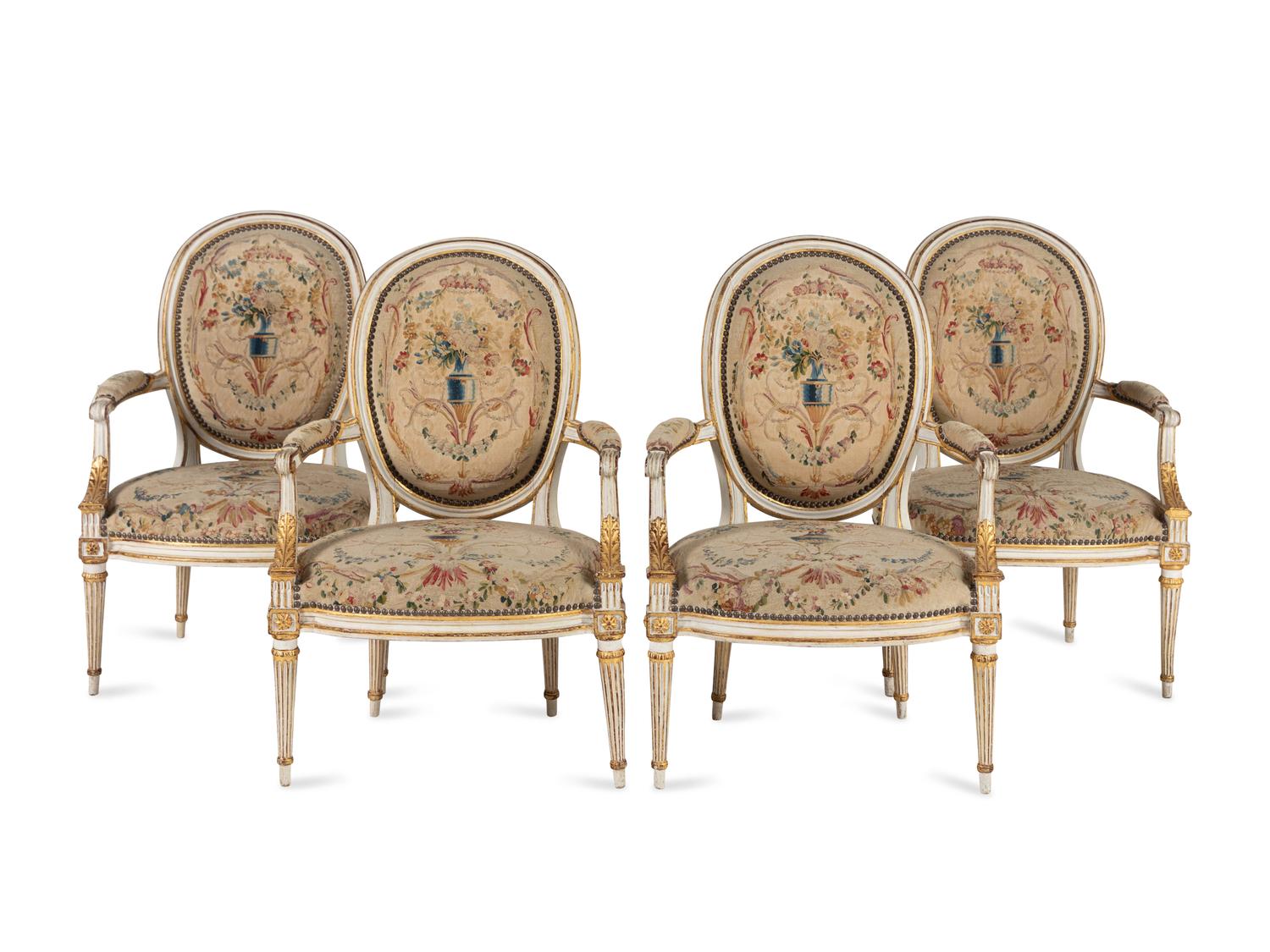 A Set of Four Louis XVI Crème-Painted and Parcel Gilt Fauteuils