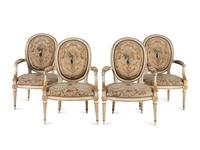 A Set of Four Louis XVI Crème-Painted and Parcel Gilt Fauteuils