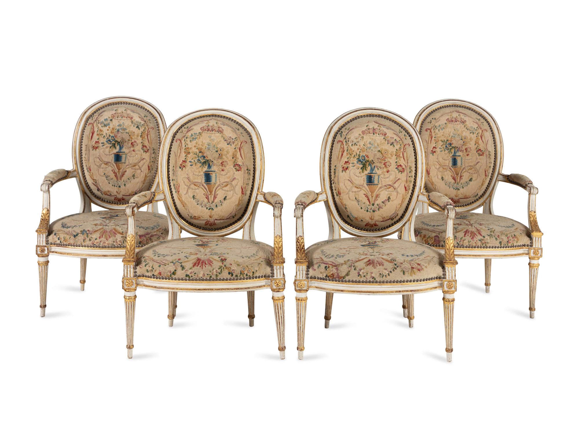 A Set of Four Louis XVI Crème-Painted and Parcel Gilt Fauteuils