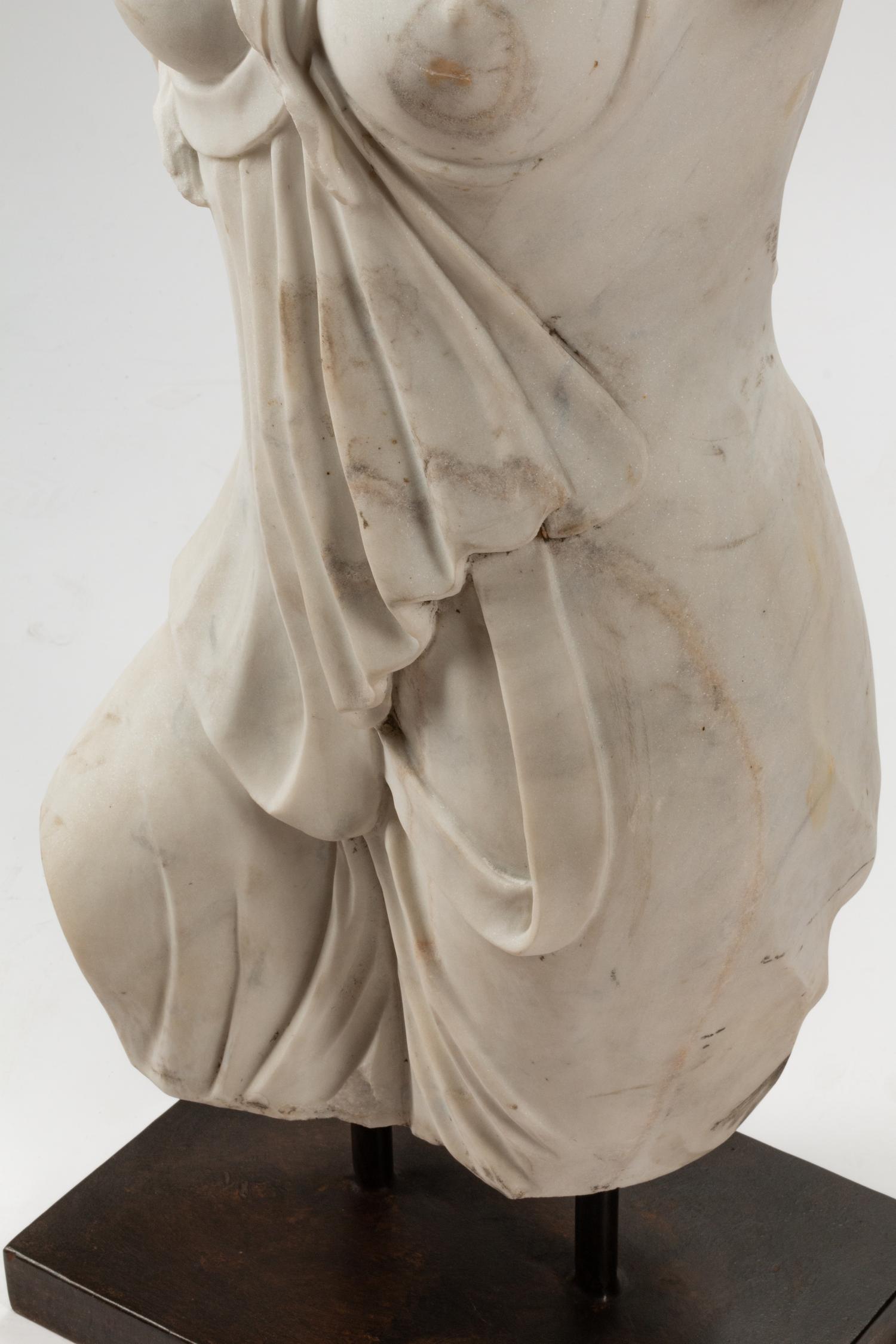 An Italian Carved White Marble Female Torso on an Iron Base