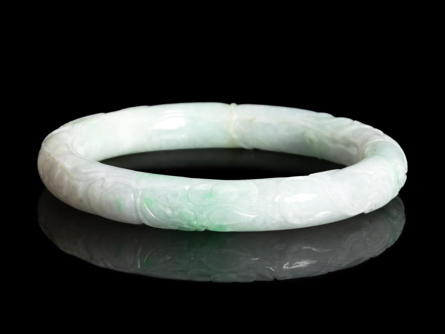 A Chinese Carved Apple Green and White Jadeite Bangle