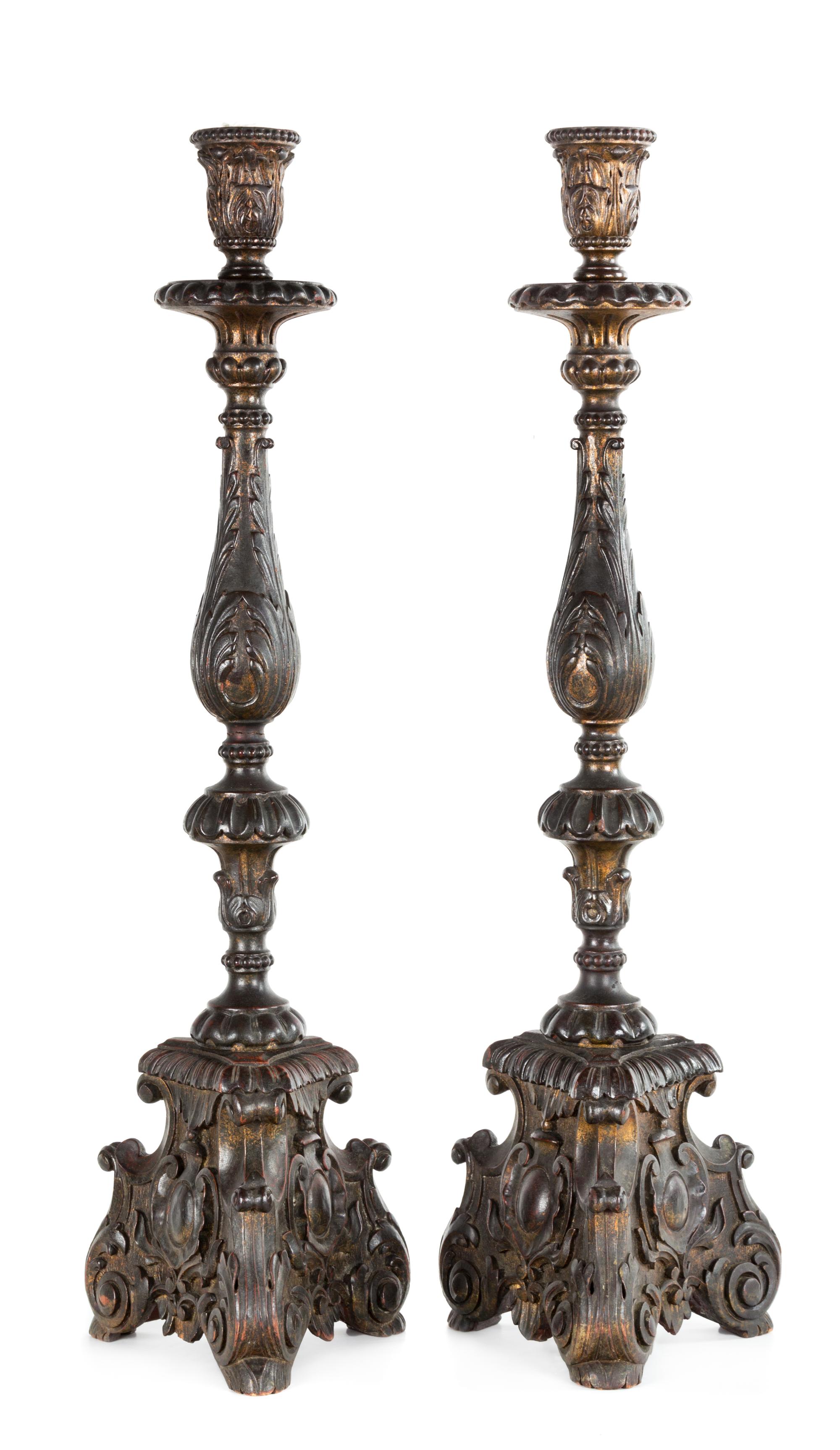 A Pair of Baroque Style Patinated Giltwood Candlesticks Height 30 1/2 inches.