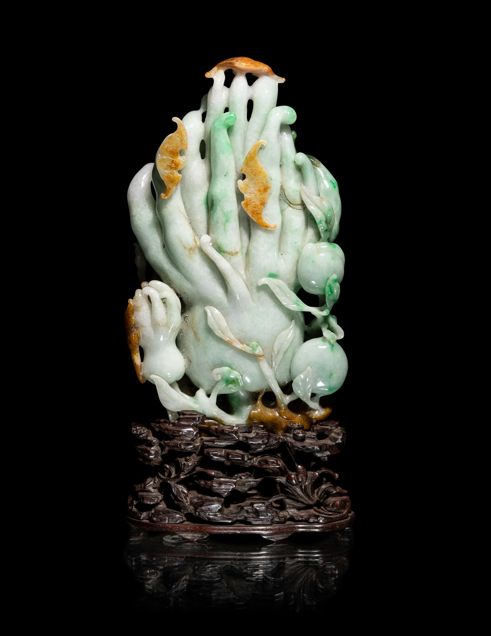 A Chinese Apple Green and Russet Jadeite Carving of Buddha's Hand Citron