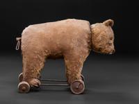 A Stuffed Bear Pull Toy with Rotating Head and Glass Eyes