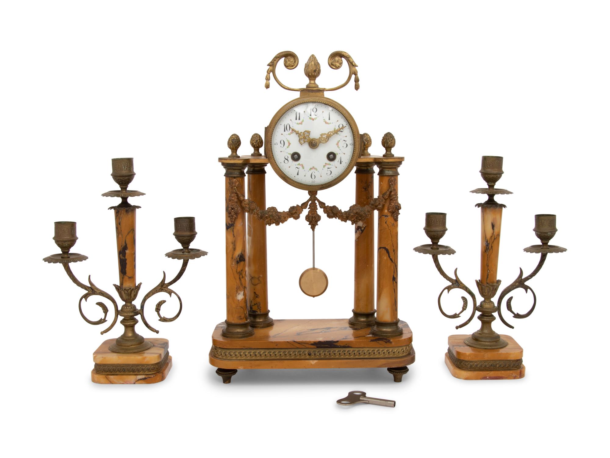 A French Gilt Metal and Siena Marble Three-Piece Clock Garniture