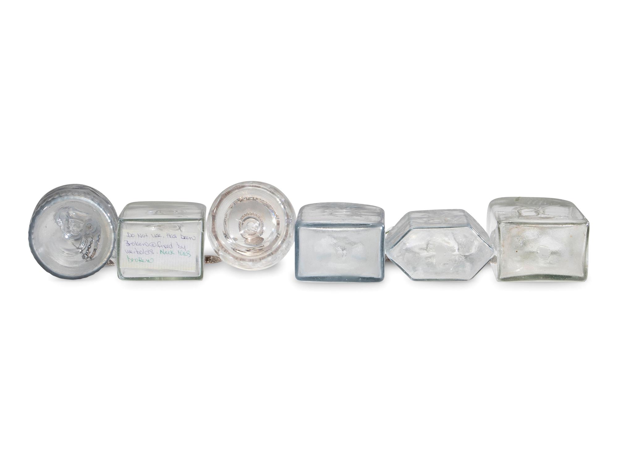 Fifteen Glass Decanters with English Shell-Form Silver Bottle Tags