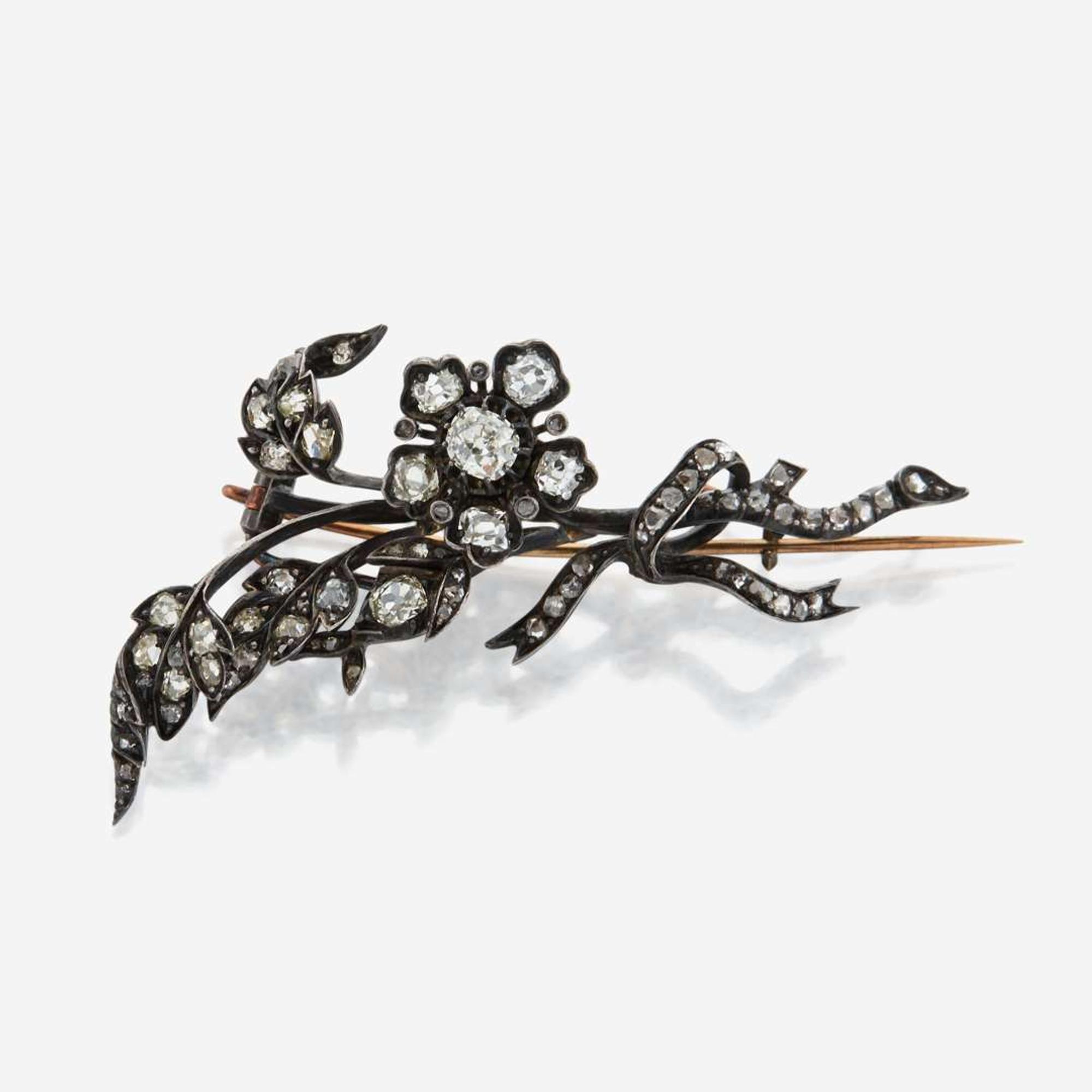 An antique diamond and silver topped gold brooch