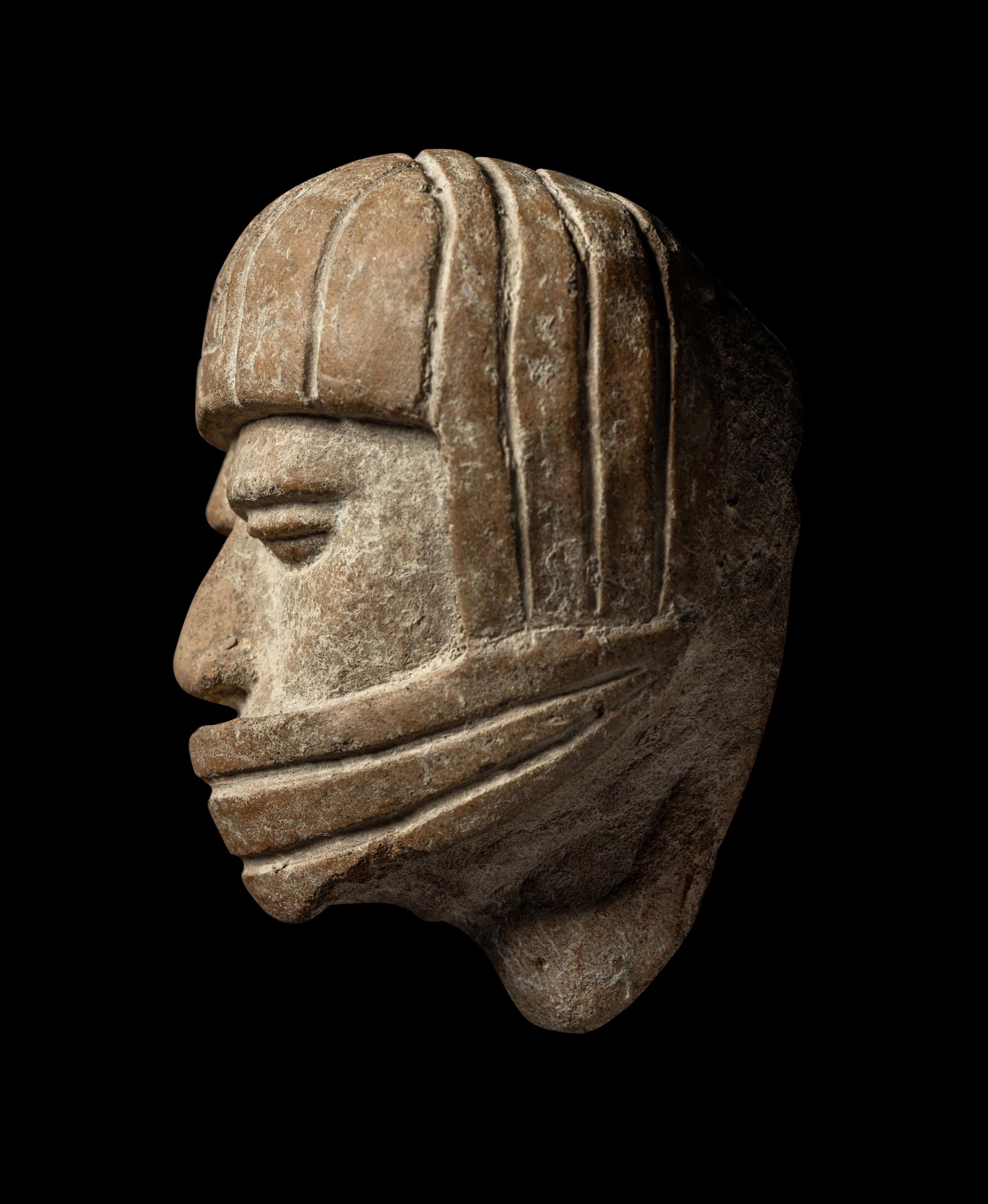 A Veracruz Terracotta Head Wearing a Helmet with an Incised Glyph