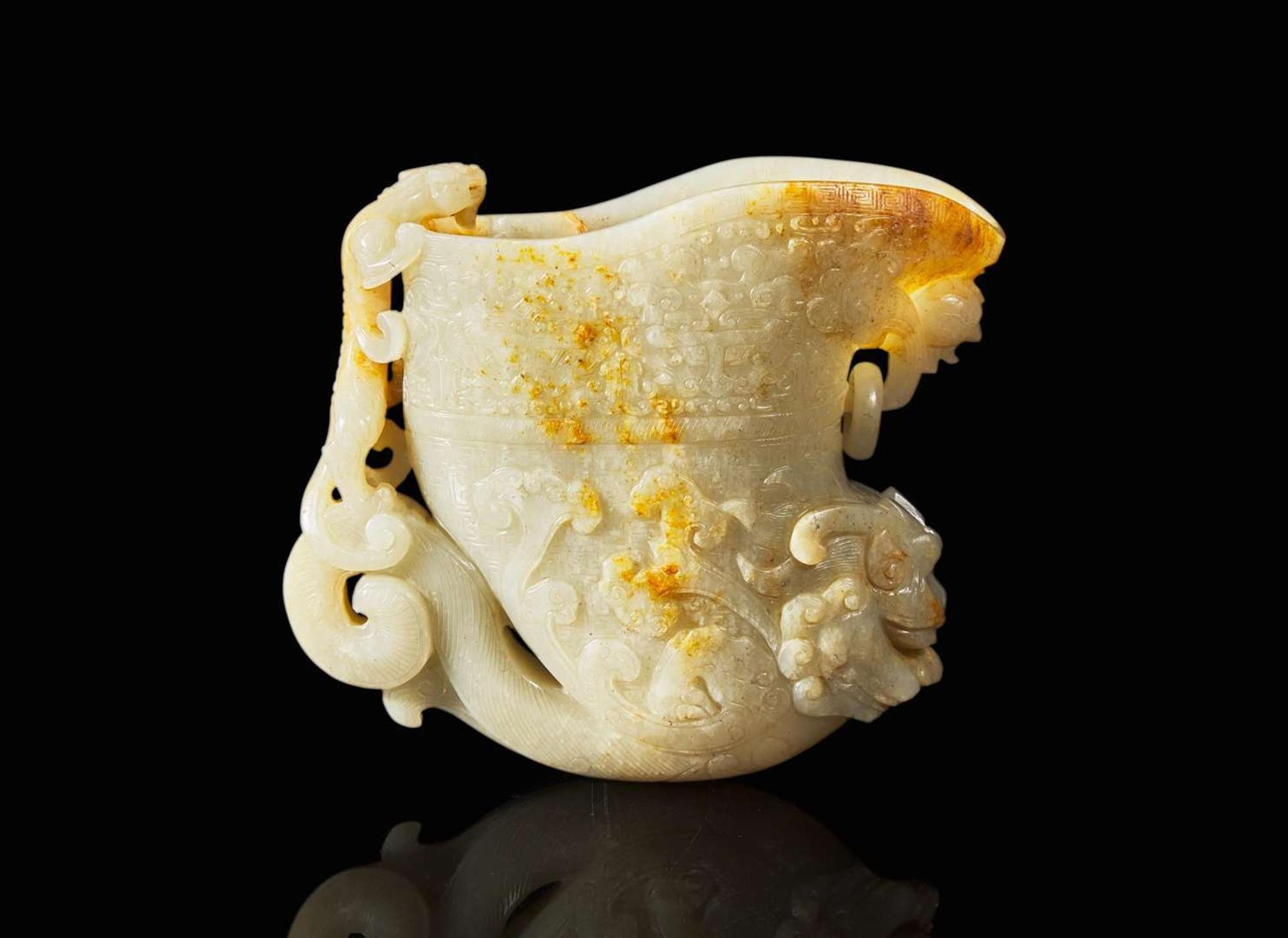A large Chinese carved pale celadon and russet jade rhyton vessel 青白玉雕觥杯