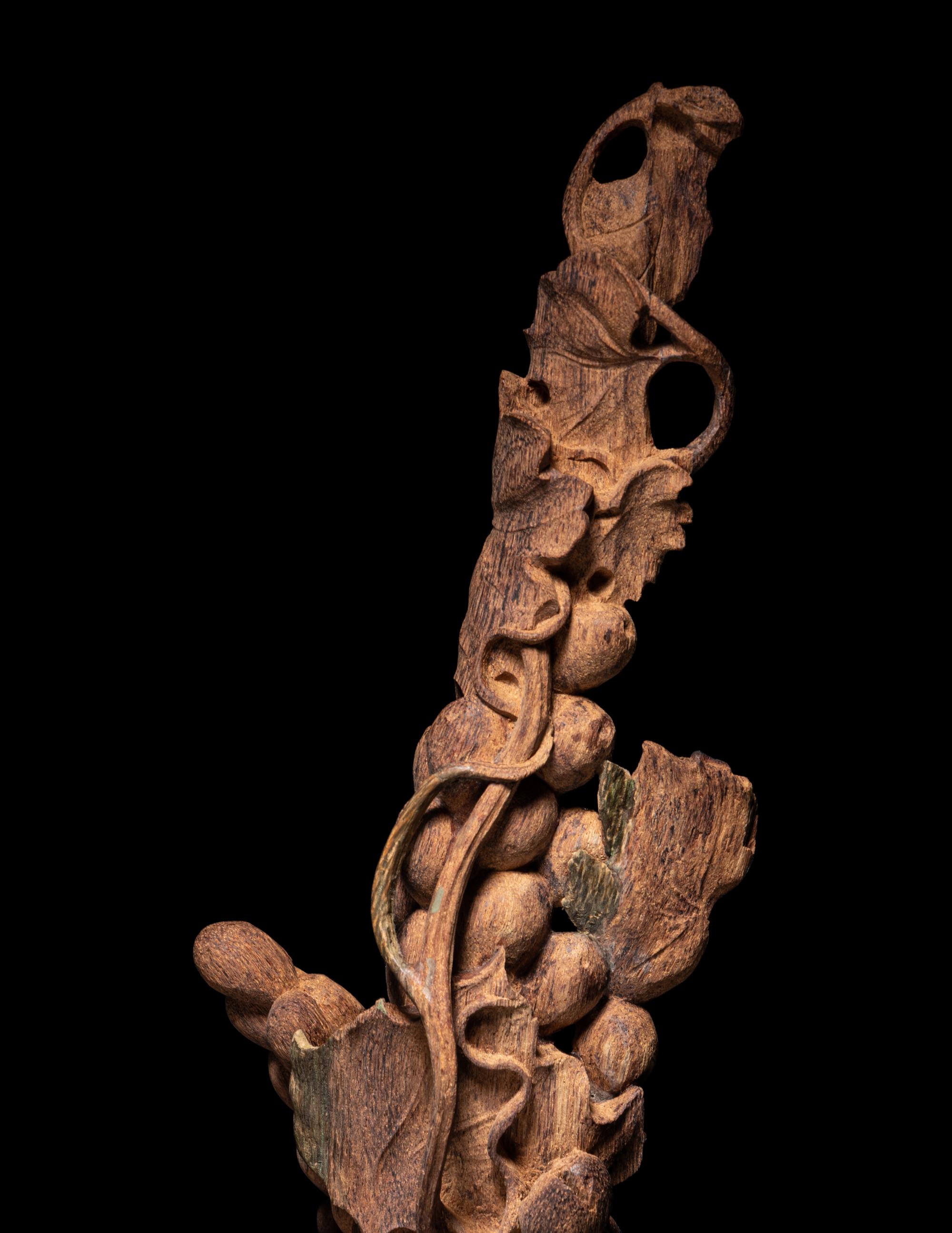 A Chinese Chenxiang Wood 'Squirrel and Grapes' Carving