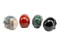 A Set of Four Carved Agate, Fluorite, Red Jasper and Black Obsidian Skulls