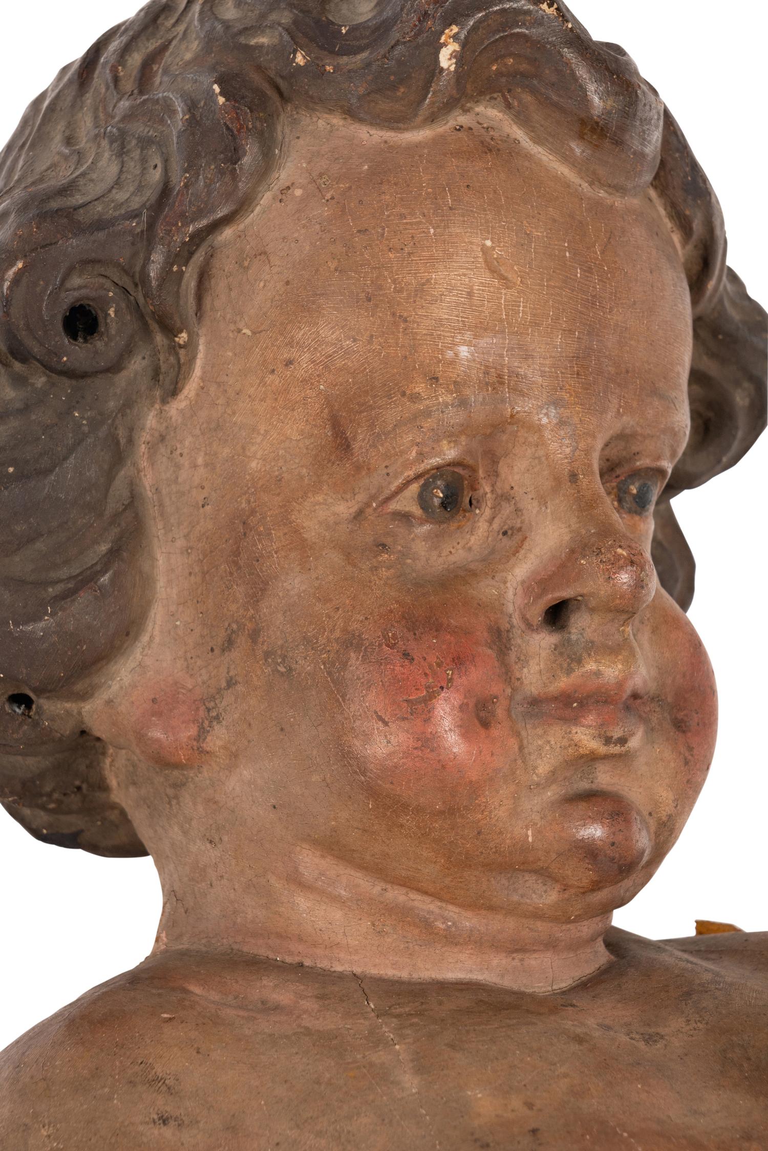 A Painted and Parcel Gilt Wood Figure of a Putto