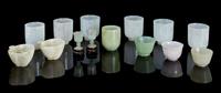 A Collection of Fourteen Jade and Jadeite Cups Height of tallest 2 3/8 inches.