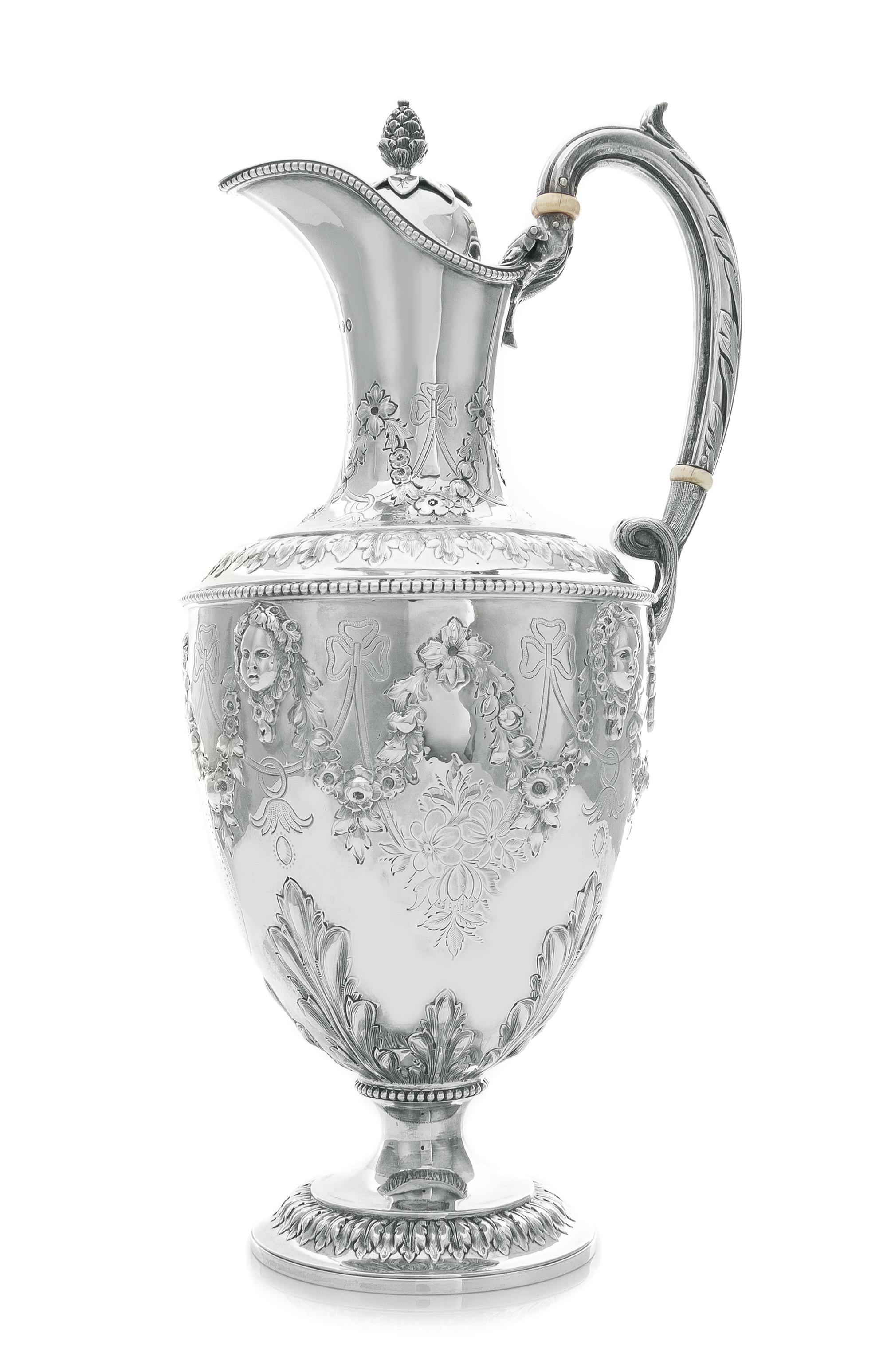 A Victorian Silver Claret Jug, Martin, Hall & Co., London, 1870, the hinged lid with a pinecone finial, the baluster form body chased w