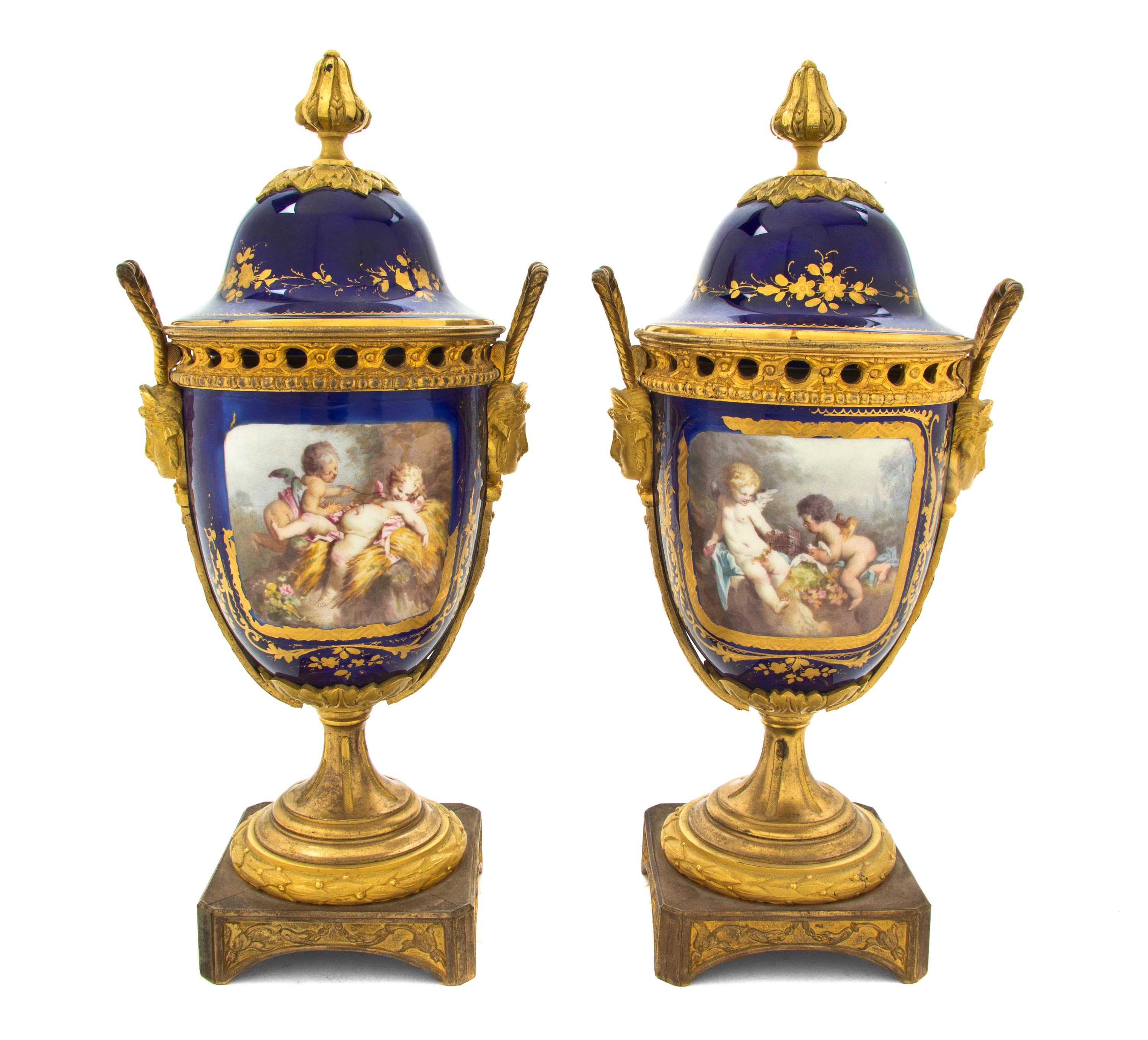 A Pair of Sevres Style Porcelain and Gilt Metal Mounted Covered Urns, Height 12 1/2 inches.