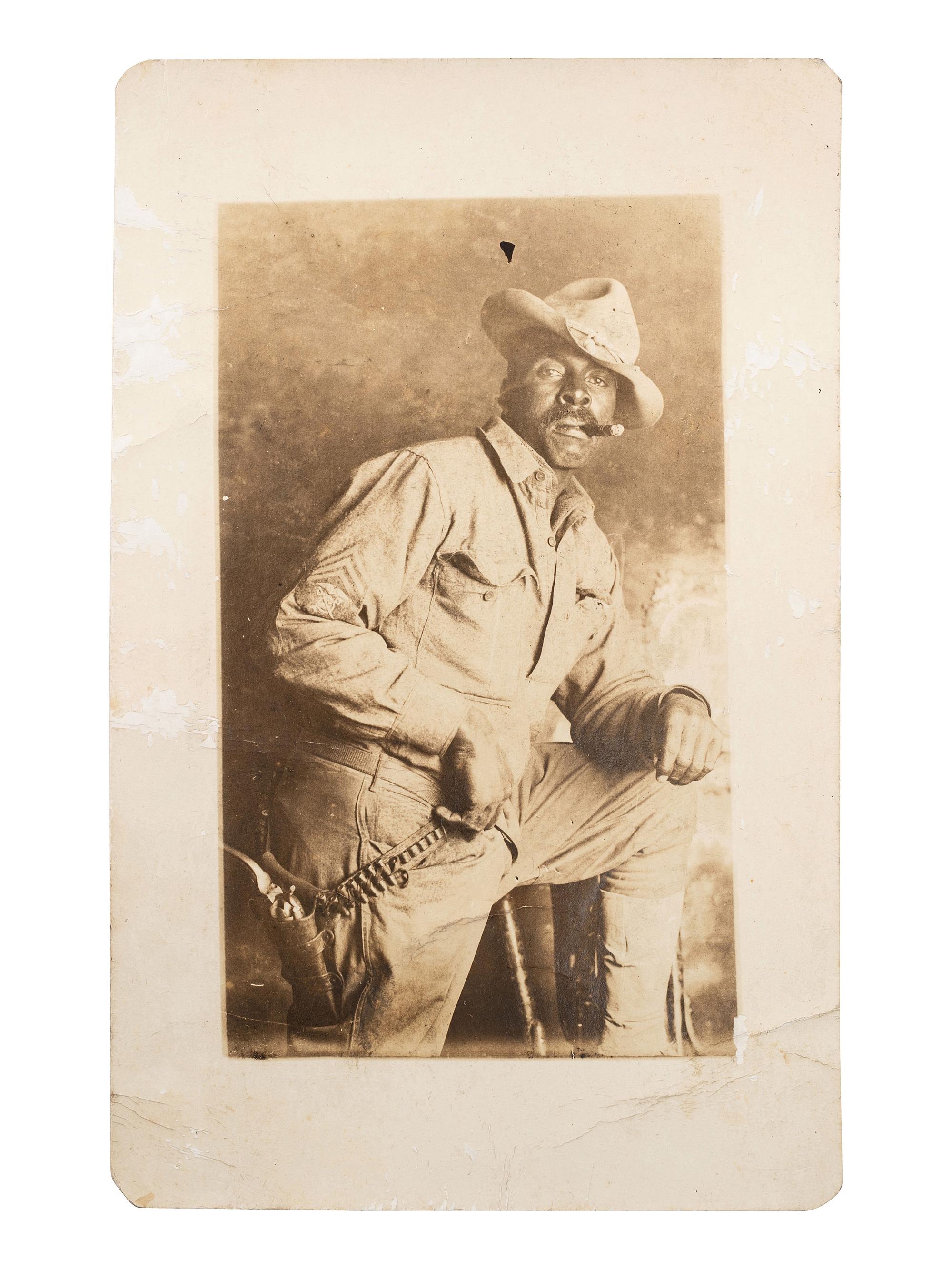 [AFRICAN AMERICANA] -- [EARLY PHOTOGRAPHY]. Real photo postcard of African American sergeant smoking cigar. Ca 1910s.