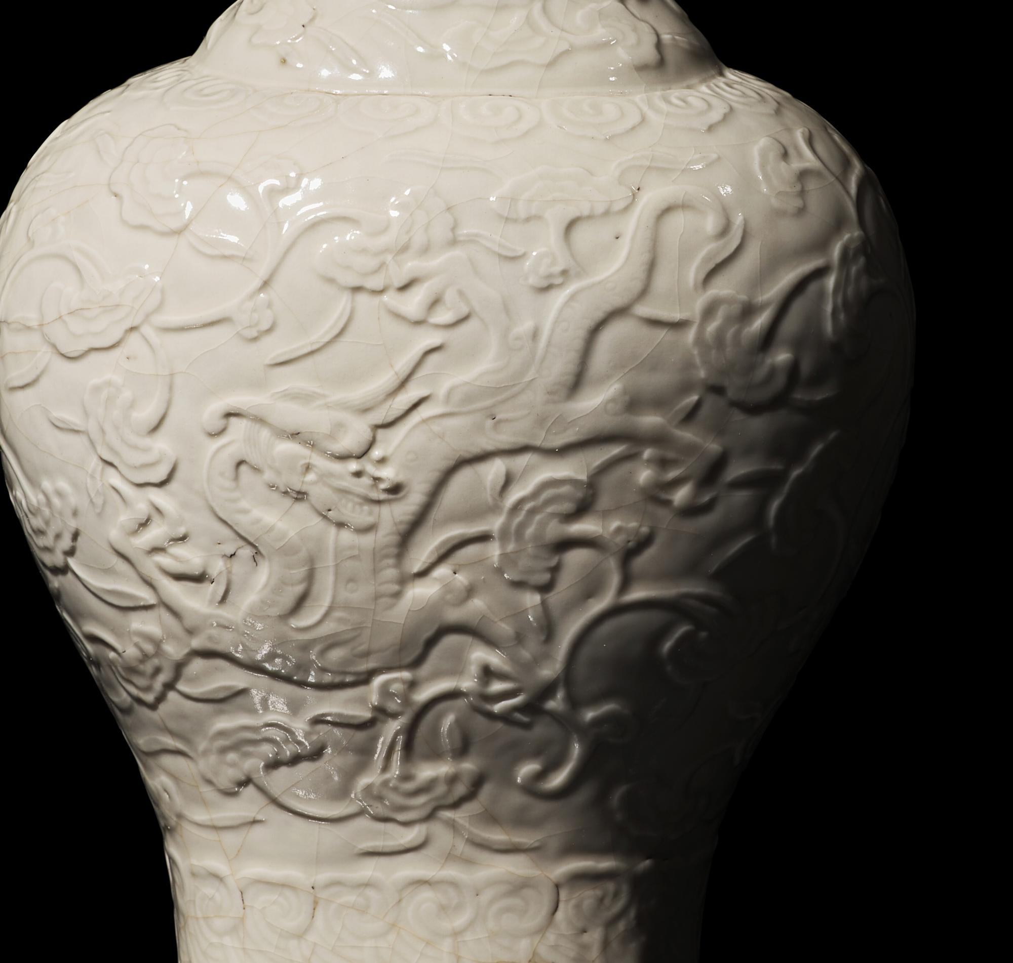 A Chinese White Glazed Soft Paste Molded 'Dragons and Lingzhi' Vase, 18th Century 清中期 白釉模印漿胎靈芝螭龍紋瓶