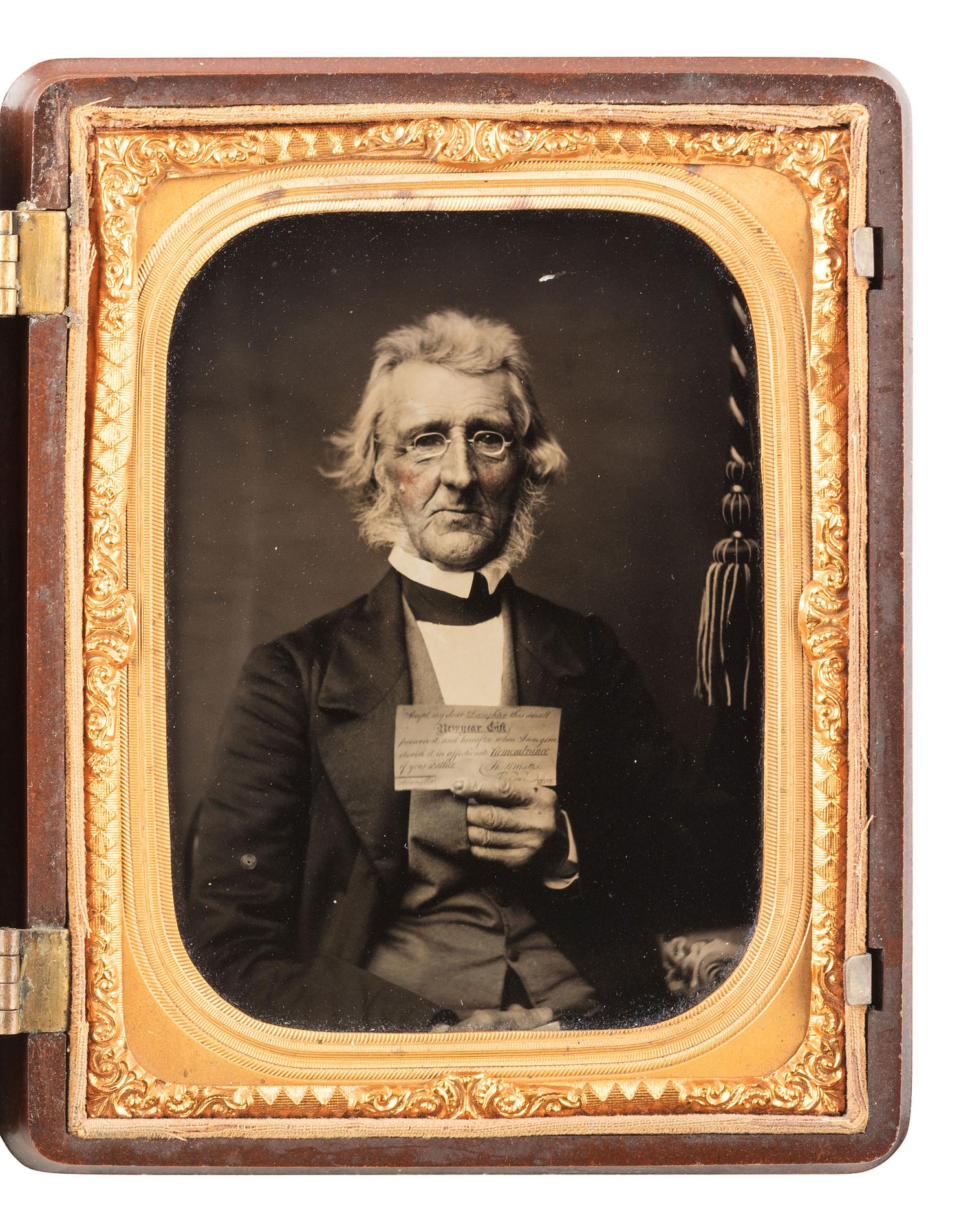 [EARLY PHOTOGRAPHY]. Quarter plate ambrotype of an aged gentleman holding up an affectionate note to his daughter. Ca 1862.