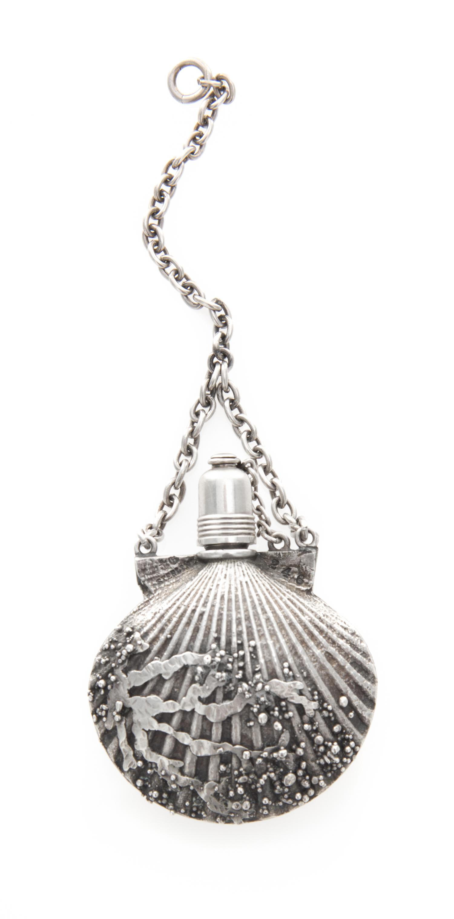 An American Silver Perfume Bottle, Gorham Mfg. Co., Providence, RI, in the form of a scallop shell suspended from a chain.