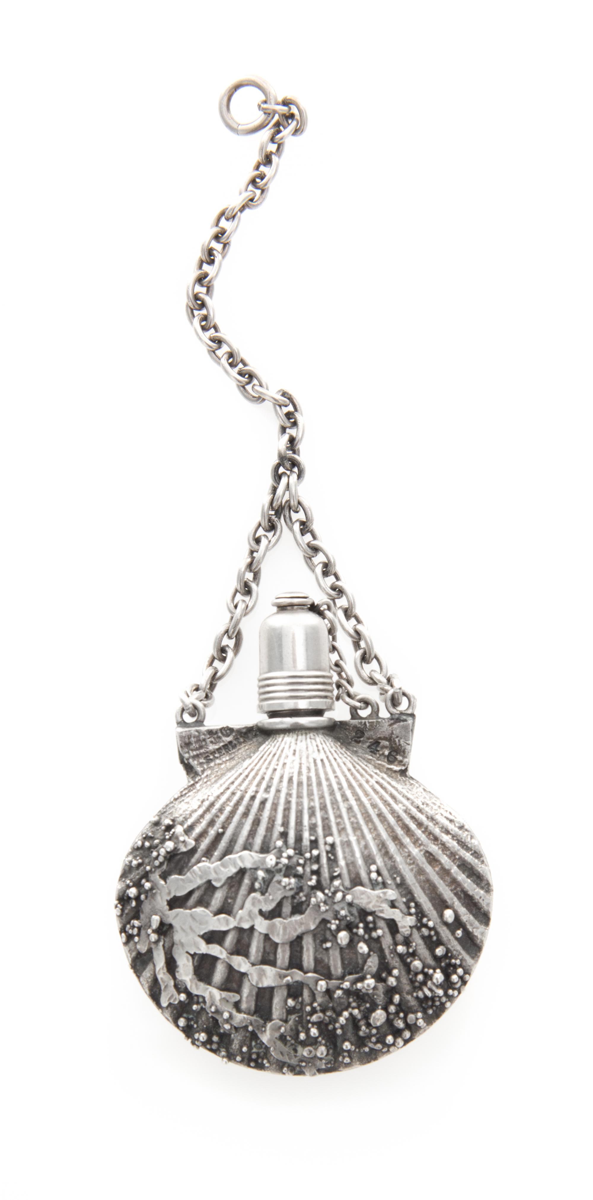 An American Silver Perfume Bottle, Gorham Mfg. Co., Providence, RI, in the form of a scallop shell suspended from a chain.